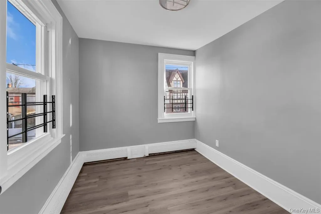 Bedroom with light wood finished floors and a baseboard heating unit Bedroom with light wood finished floors and a baseboard heating unit