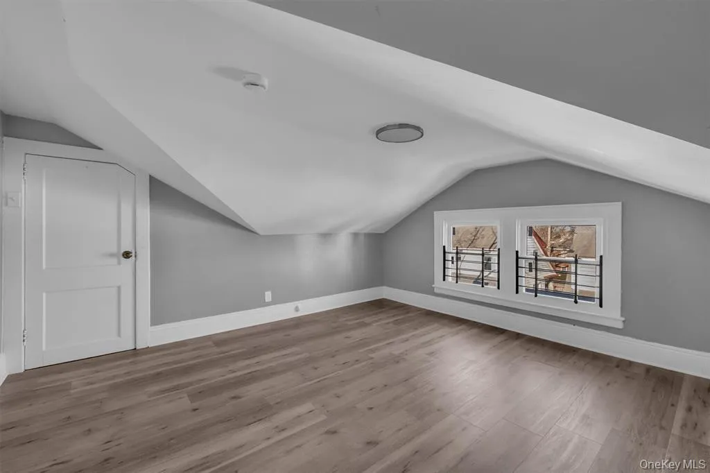 Additional living space featuring light wood-style flooring and lofted ceiling Additional living space featuring light wood-style flooring and lofted ceiling
