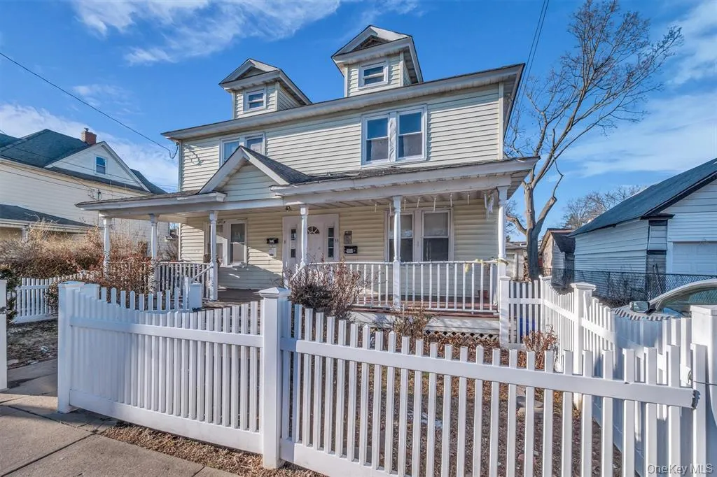 Traditional style home featuring covered porch and a fenced front yard Traditional style home featuring covered porch and a fenced front yard