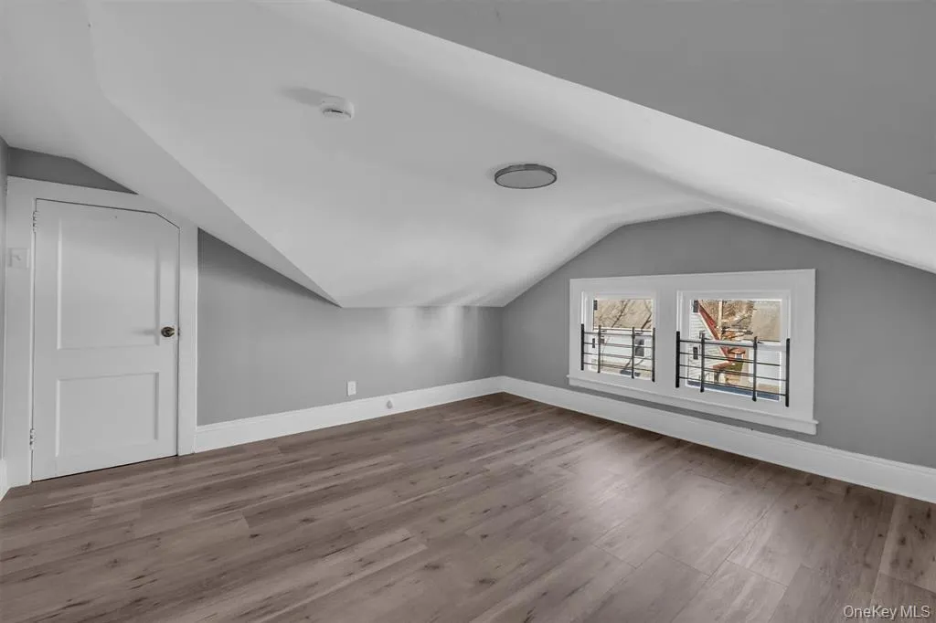 Bonus room featuring light wood-style floors and vaulted ceiling Bonus room featuring light wood-style floors and vaulted ceiling