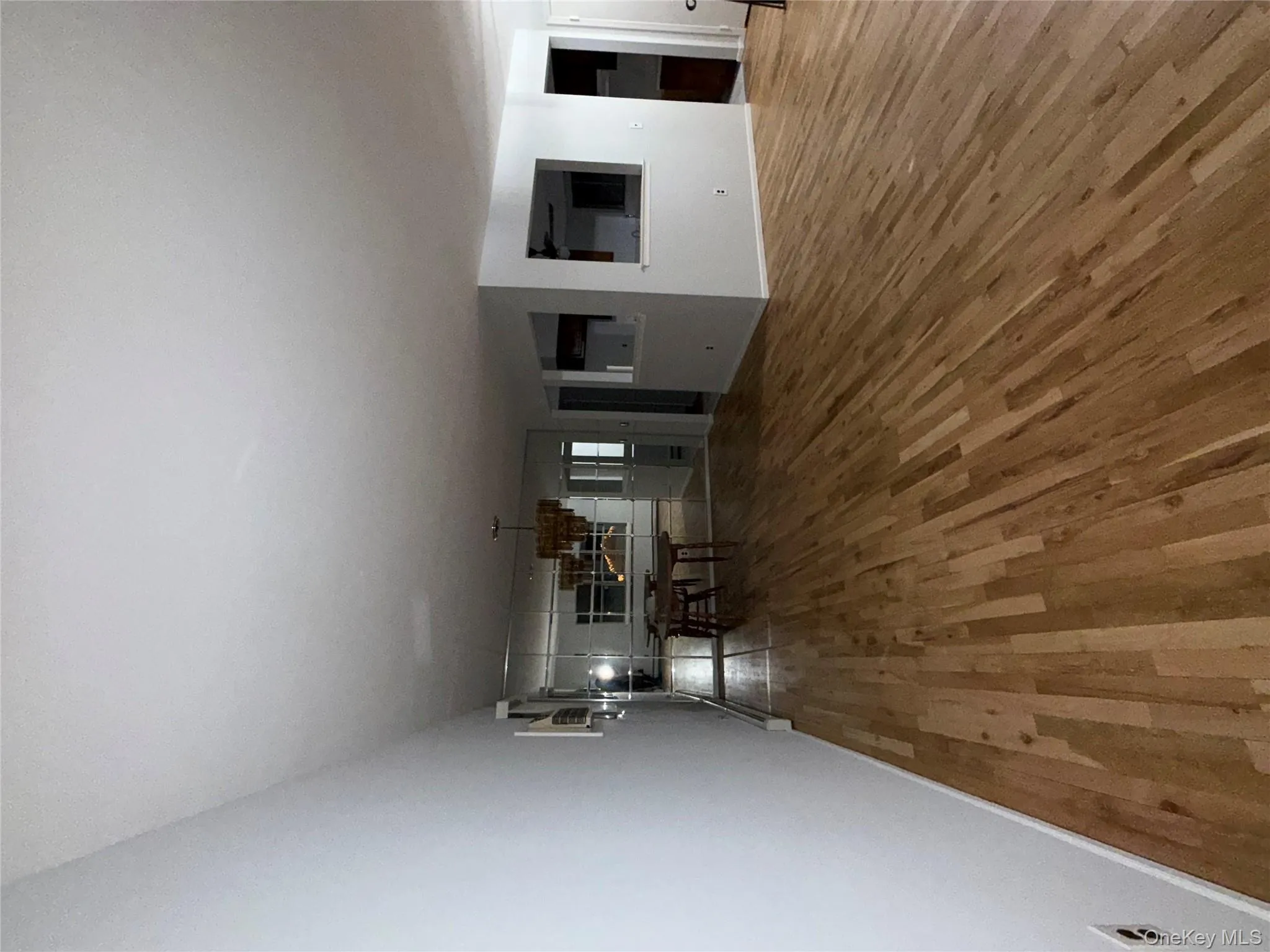 Unfurnished living room with wood finished floors and a chandelier Unfurnished living room with wood finished floors and a chandelier