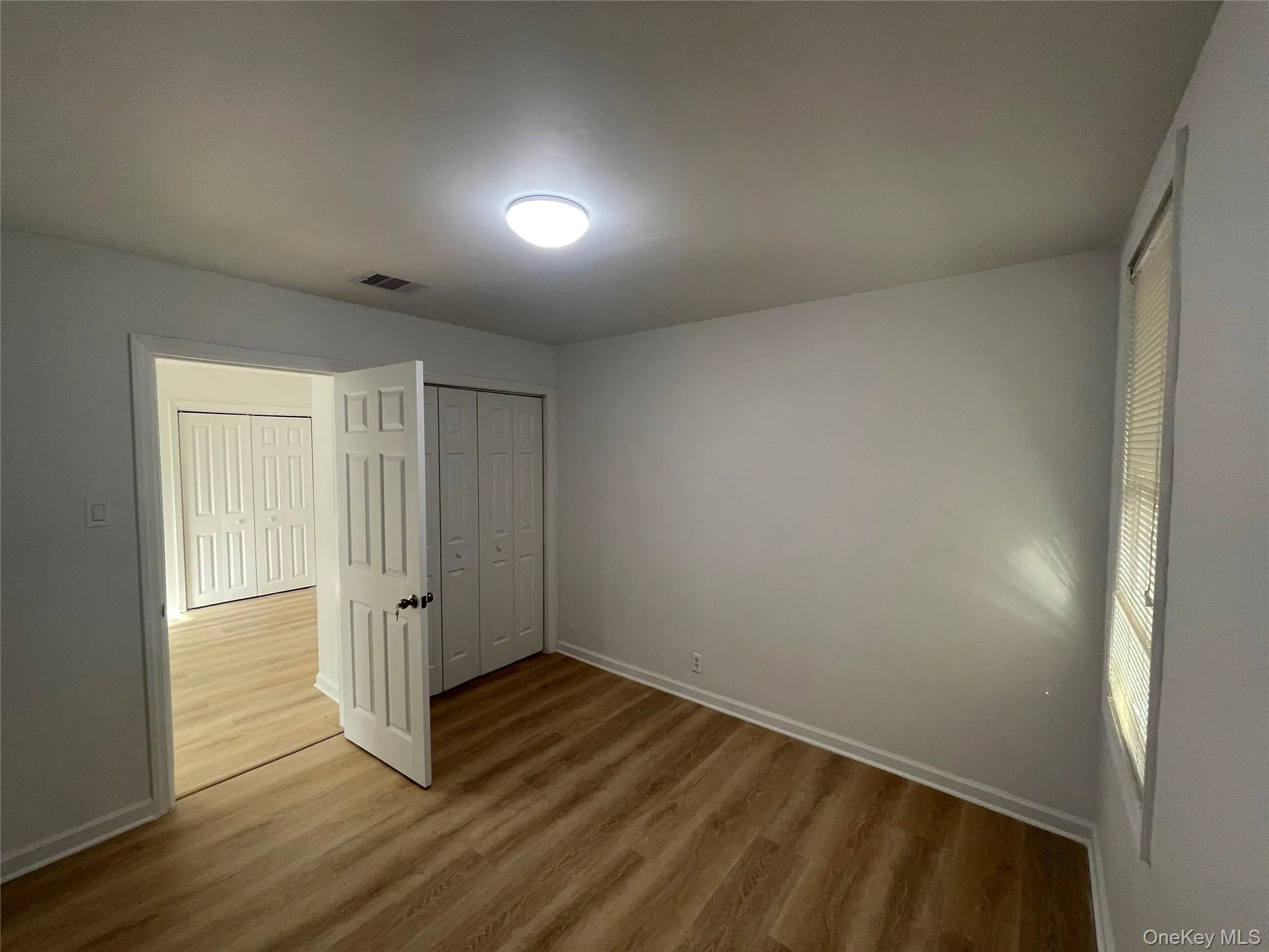 Unfurnished bedroom with a closet and light wood-style floors Unfurnished bedroom with a closet and light wood-style floors