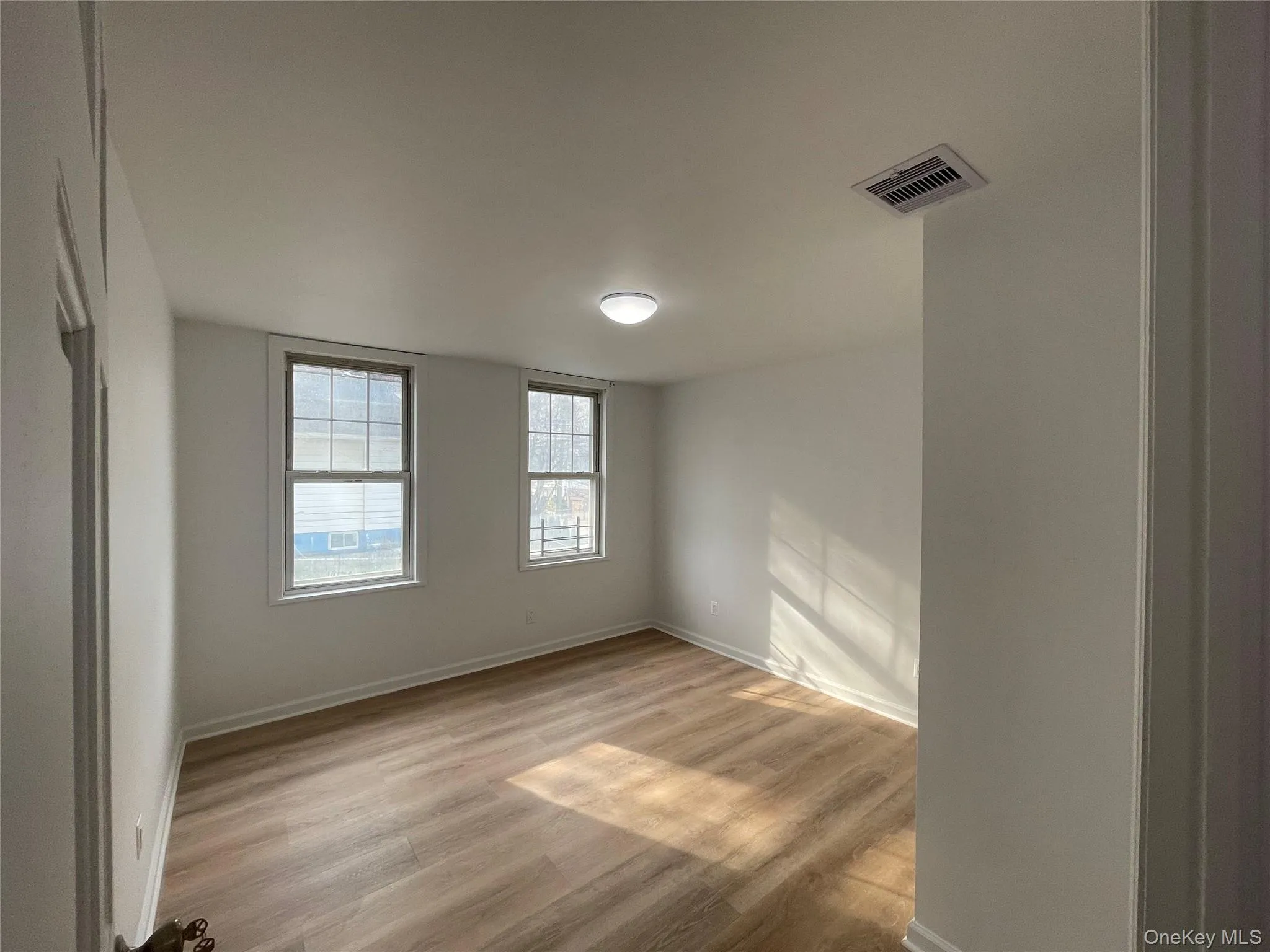 Spare room featuring light wood-type flooring and baseboards Spare room featuring light wood-type flooring and baseboards