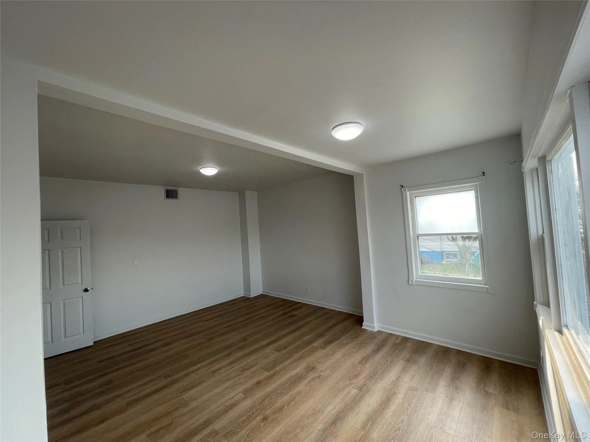 Spare room with light wood-type flooring and baseboards Spare room with light wood-type flooring and baseboards
