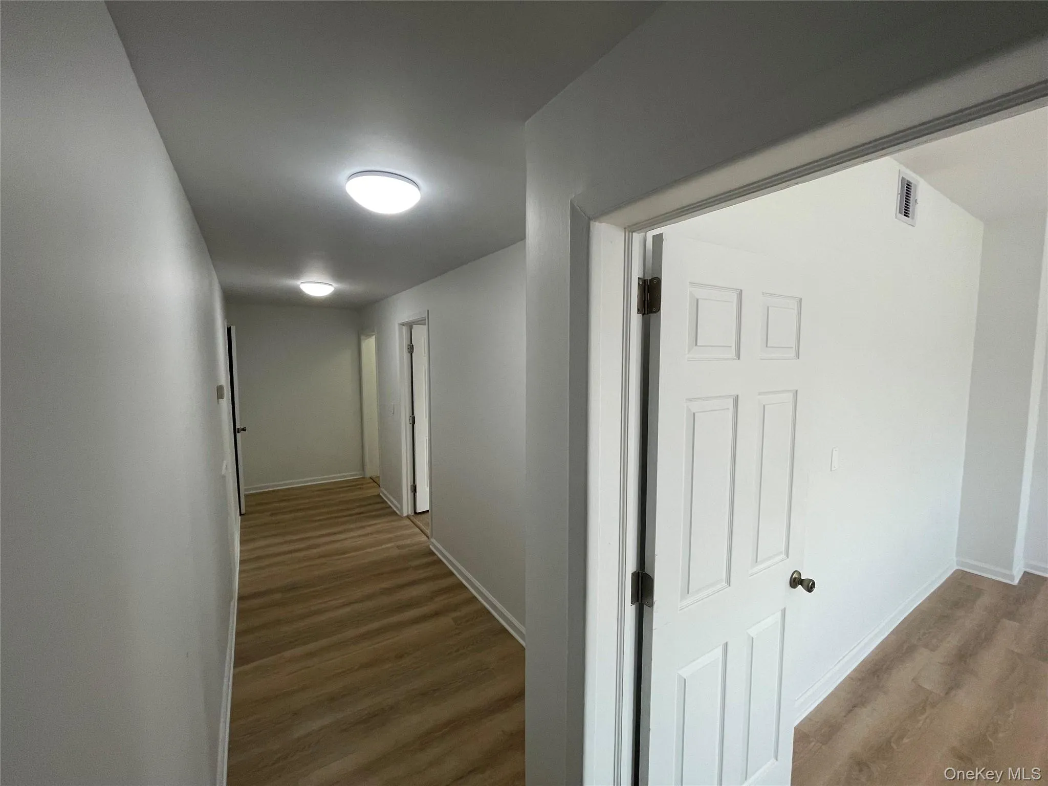 Hall featuring wood finished floors and baseboards Hall featuring wood finished floors and baseboards