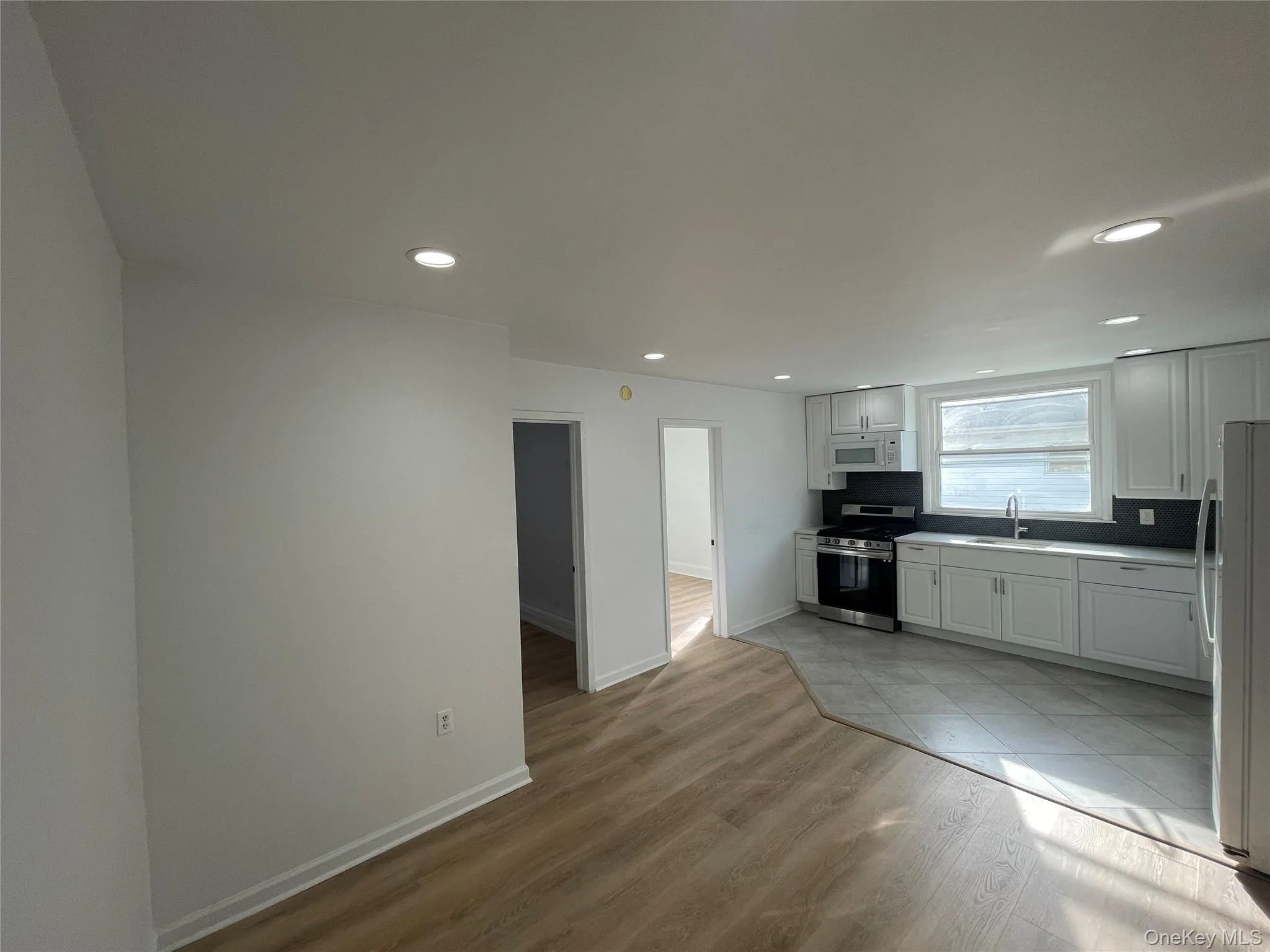 Kitchen with white cabinetry, appliances with stainless steel finishes, recessed lighting, light wood-style flooring, and light countertops Kitchen with white cabinetry, appliances with stainless steel finishes, recessed lighting, light wood-style flooring, and light countertops