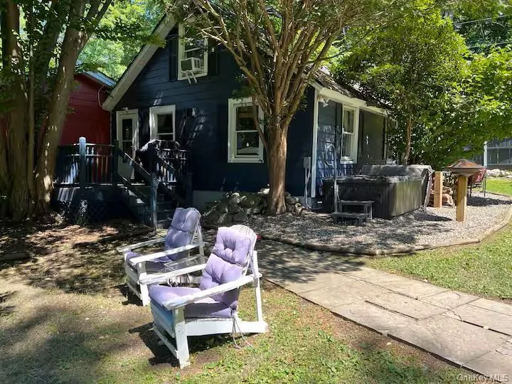 Back of house featuring a hot tub Back of house featuring a hot tub