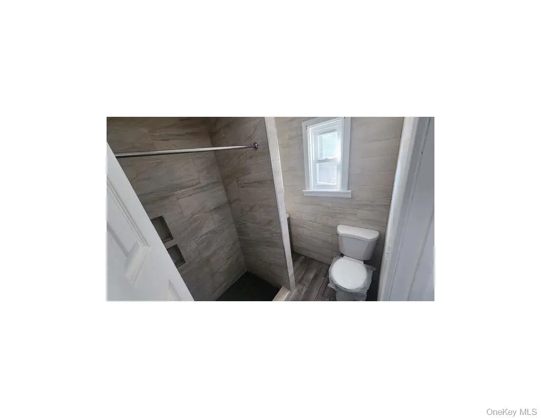 Full bathroom with toilet and tiled shower Full bathroom with toilet and tiled shower