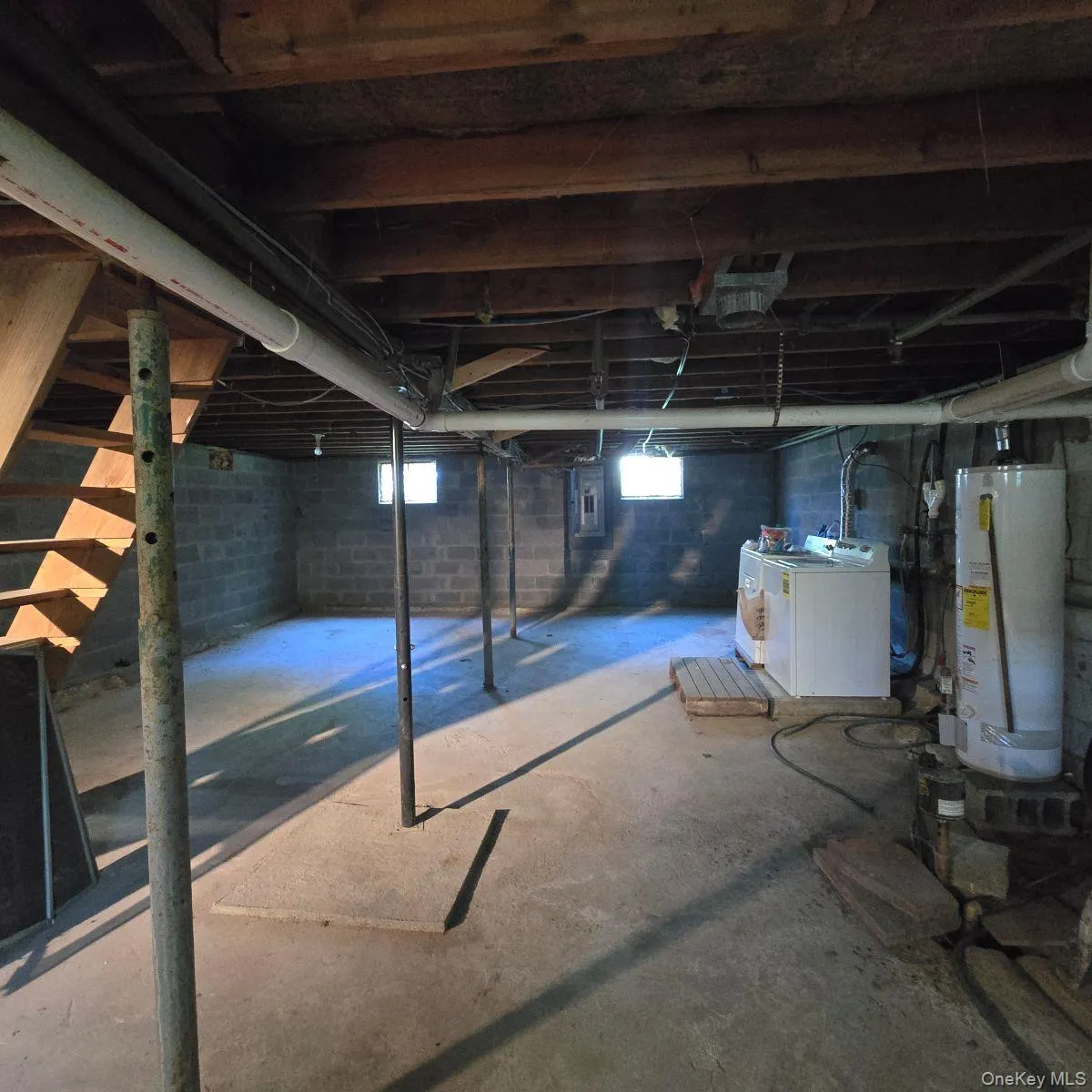 Basement with gas water heater, washing machine and clothes dryer, and electric panel Basement with gas water heater, washing machine and clothes dryer, and electric panel