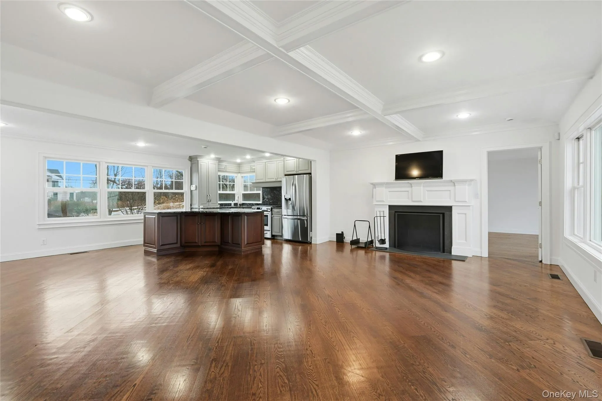 Living area with plenty of natural light, beam ceiling, dark wood finished floors, recessed lighting, and coffered ceiling Living area with plenty of natural light, beam ceiling, dark wood finished floors, recessed lighting, and coffered ceiling