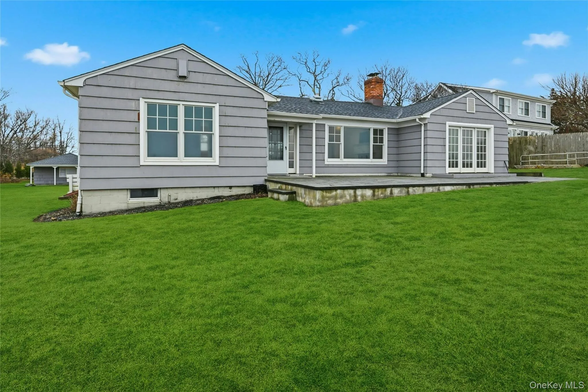 Back of property with french doors, a chimney, and roof with shingles Back of property with french doors, a chimney, and roof with shingles