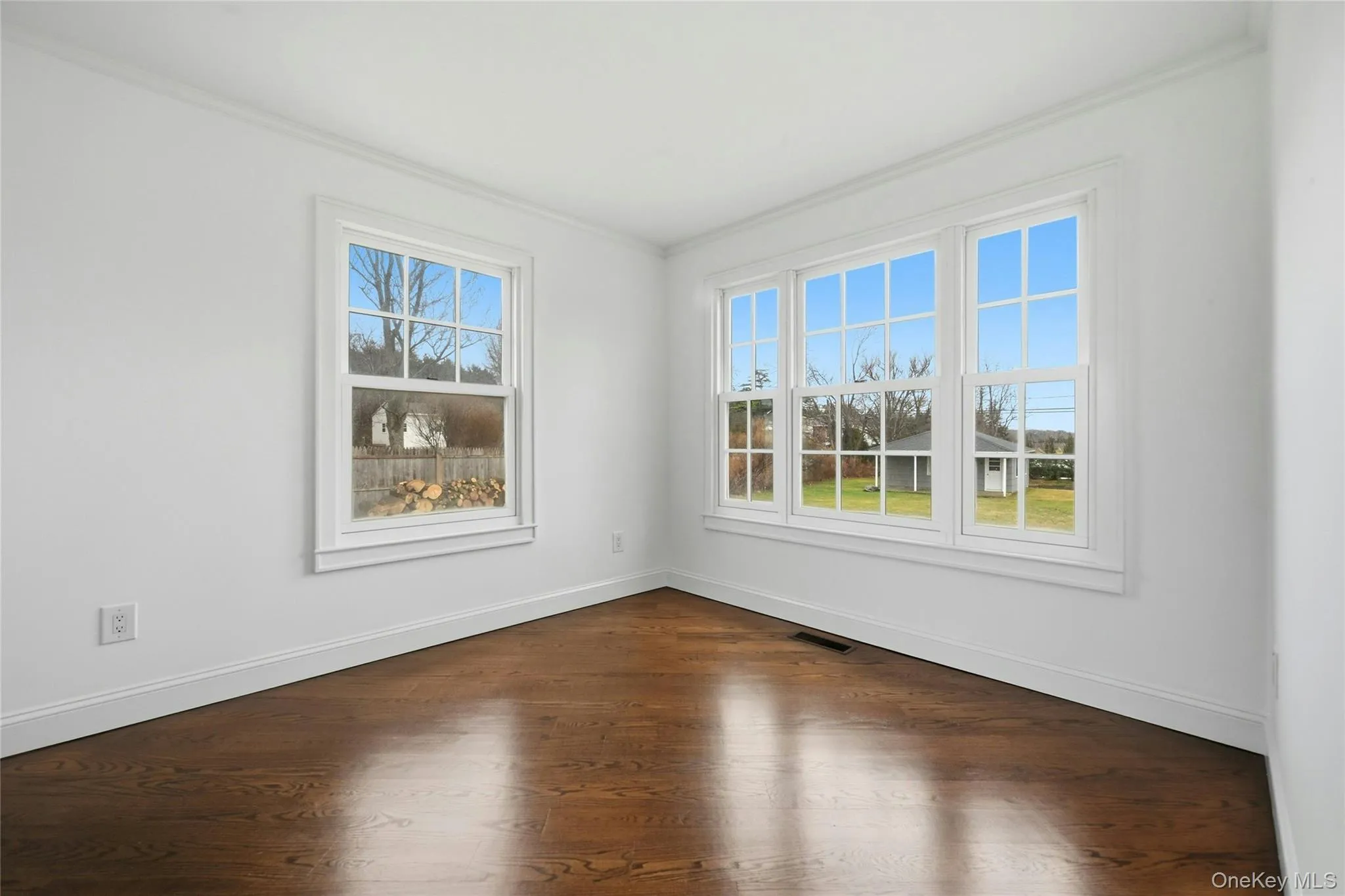 Spare room with dark wood-style floors and ornamental molding Spare room with dark wood-style floors and ornamental molding