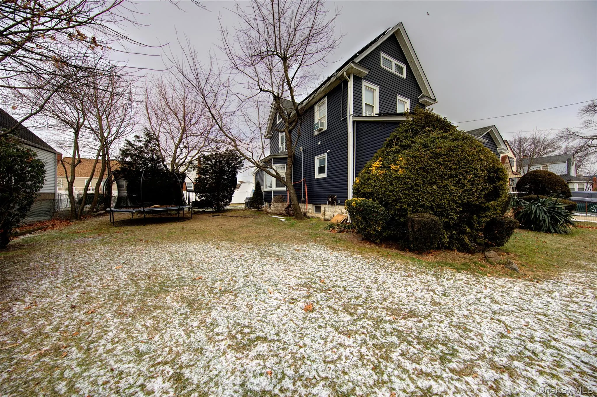 View of home's exterior with a trampoline and a deck View of home's exterior with a trampoline and a deck
