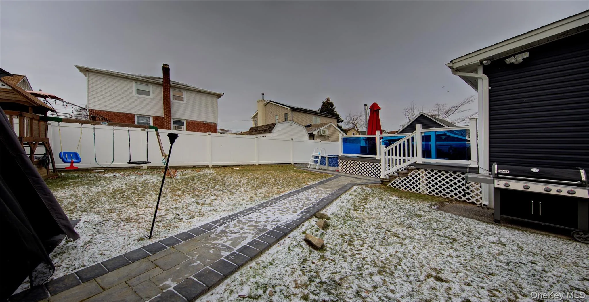 Fenced backyard featuring a wooden deck and a playground Fenced backyard featuring a wooden deck and a playground