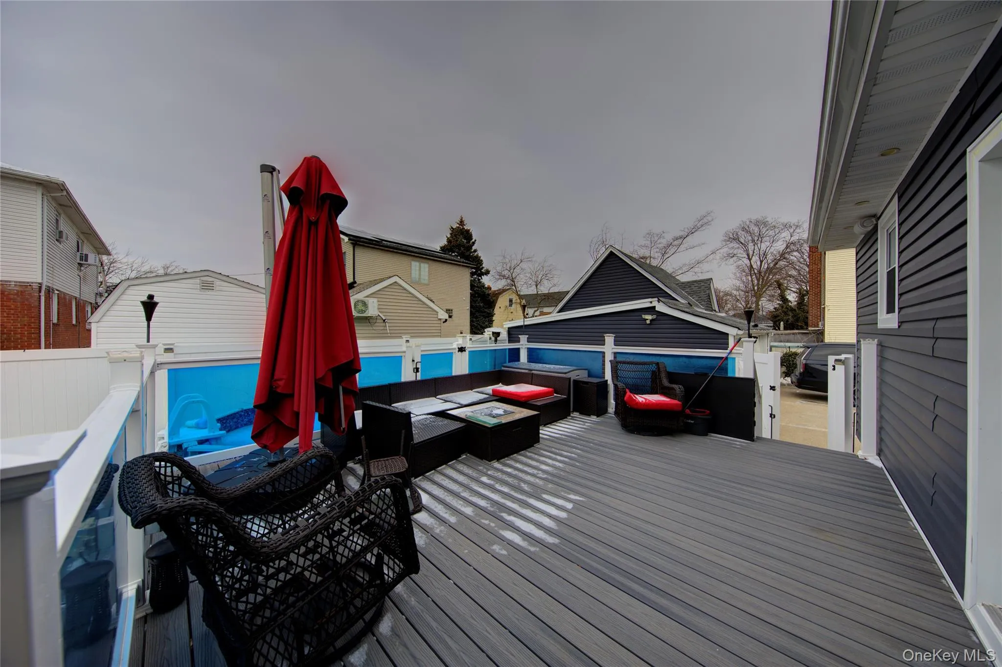Wooden terrace featuring a fenced backyard and an outdoor living space with a fire pit Wooden terrace featuring a fenced backyard and an outdoor living space with a fire pit