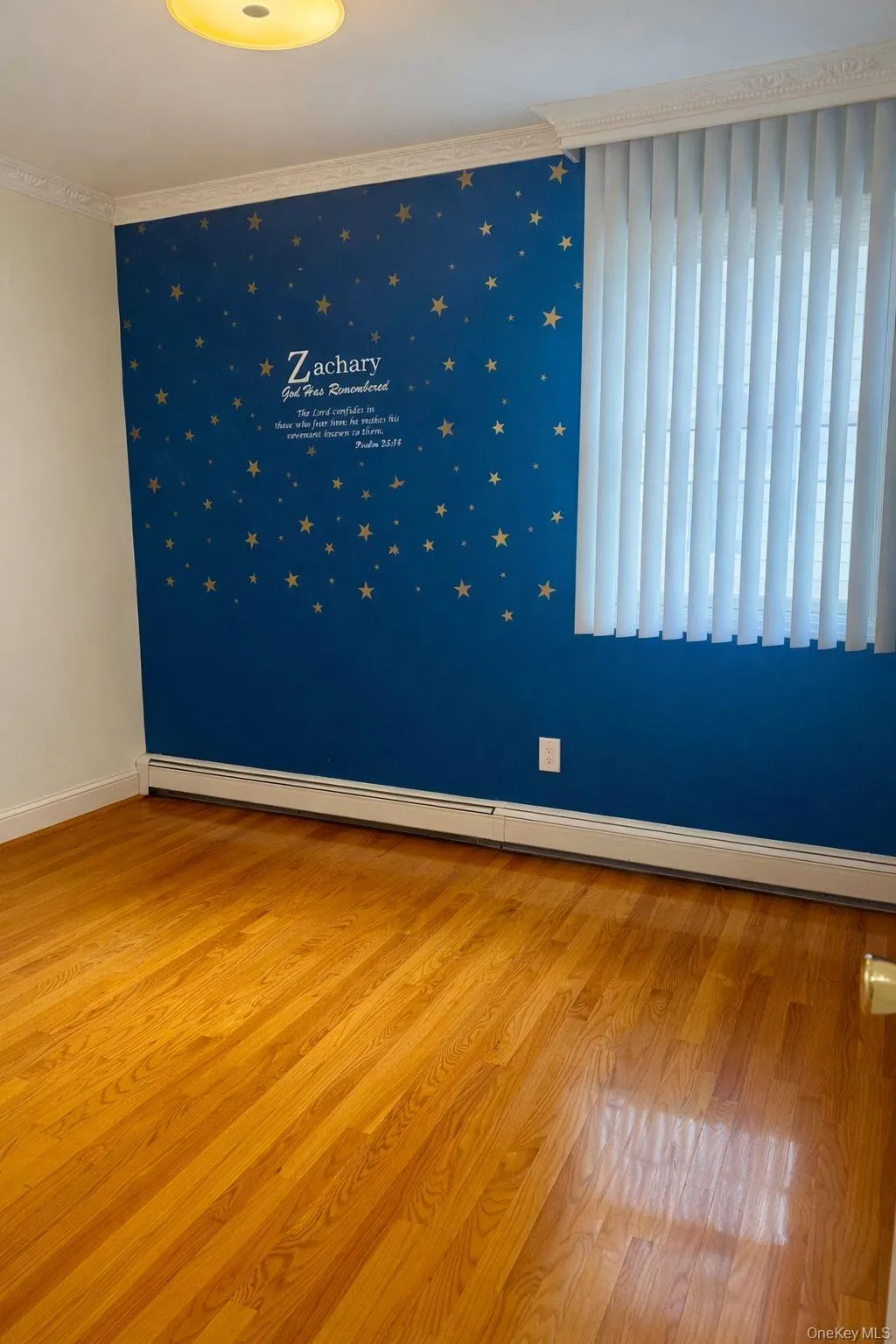 Empty room with baseboard heating, light wood-type flooring, and ornamental molding Empty room with baseboard heating, light wood-type flooring, and ornamental molding