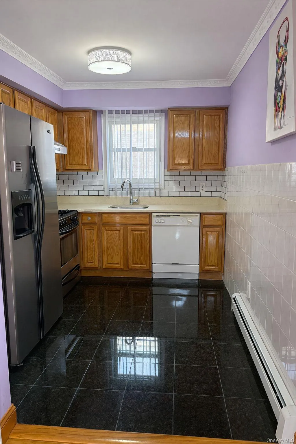 Kitchen with baseboard heating, stainless steel fridge, brown cabinets, crown molding, and dishwasher Kitchen with baseboard heating, stainless steel fridge, brown cabinets, crown molding, and dishwasher