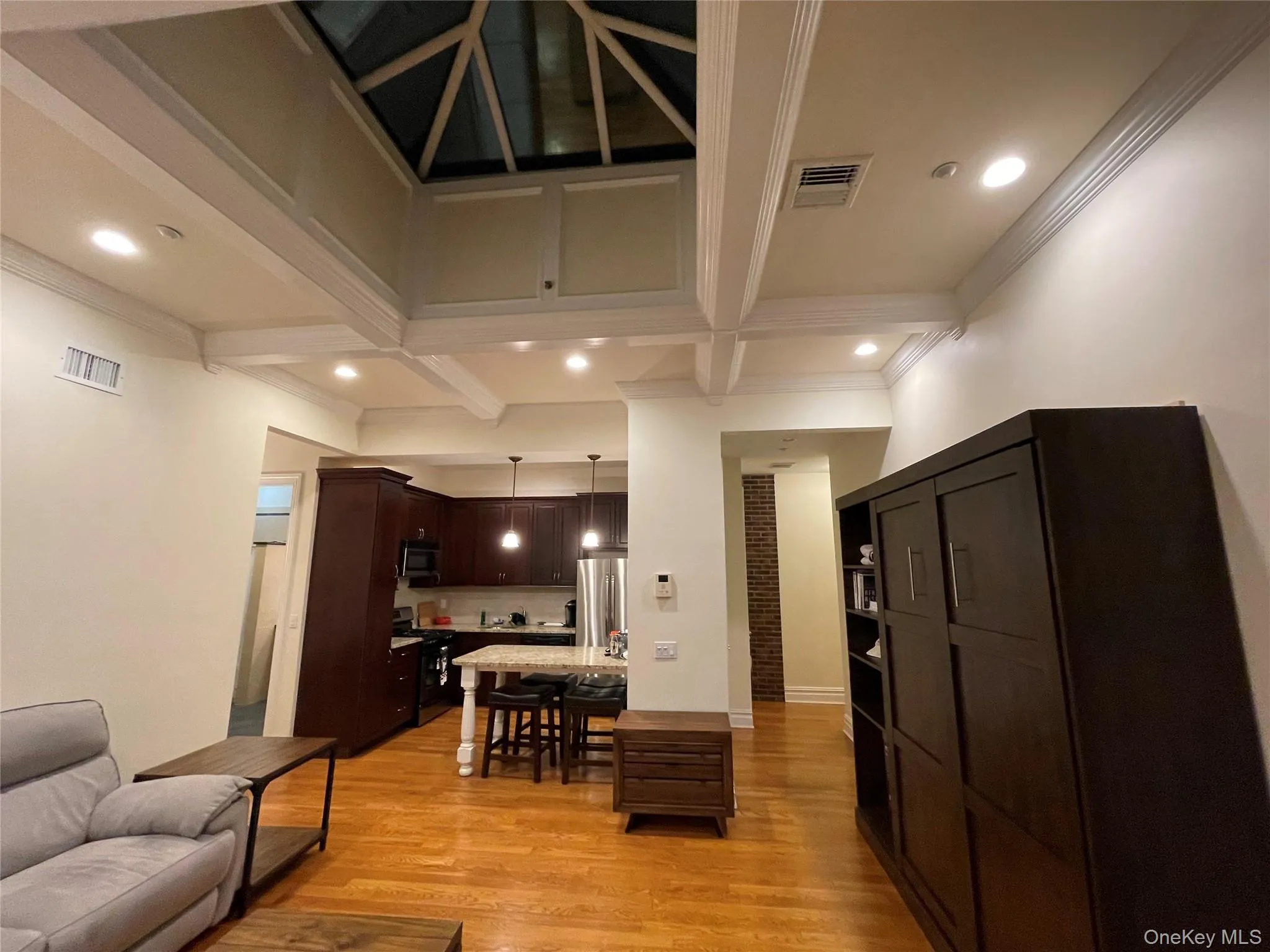Living room with light wood finished floors, recessed lighting, coffered ceiling, and beam ceiling Living room with light wood finished floors, recessed lighting, coffered ceiling, and beam ceiling