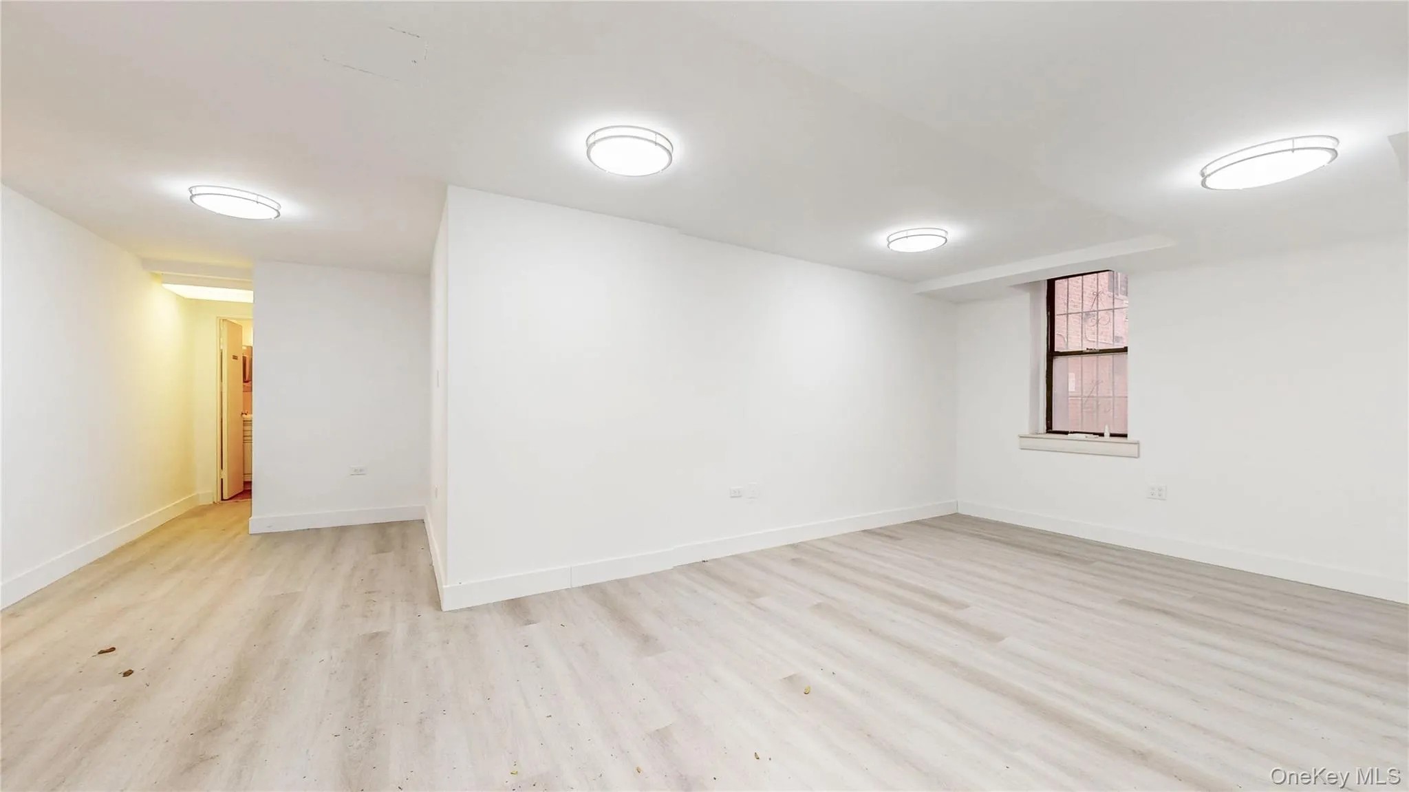 Unfurnished room with baseboards and light wood-type flooring Unfurnished room with baseboards and light wood-type flooring