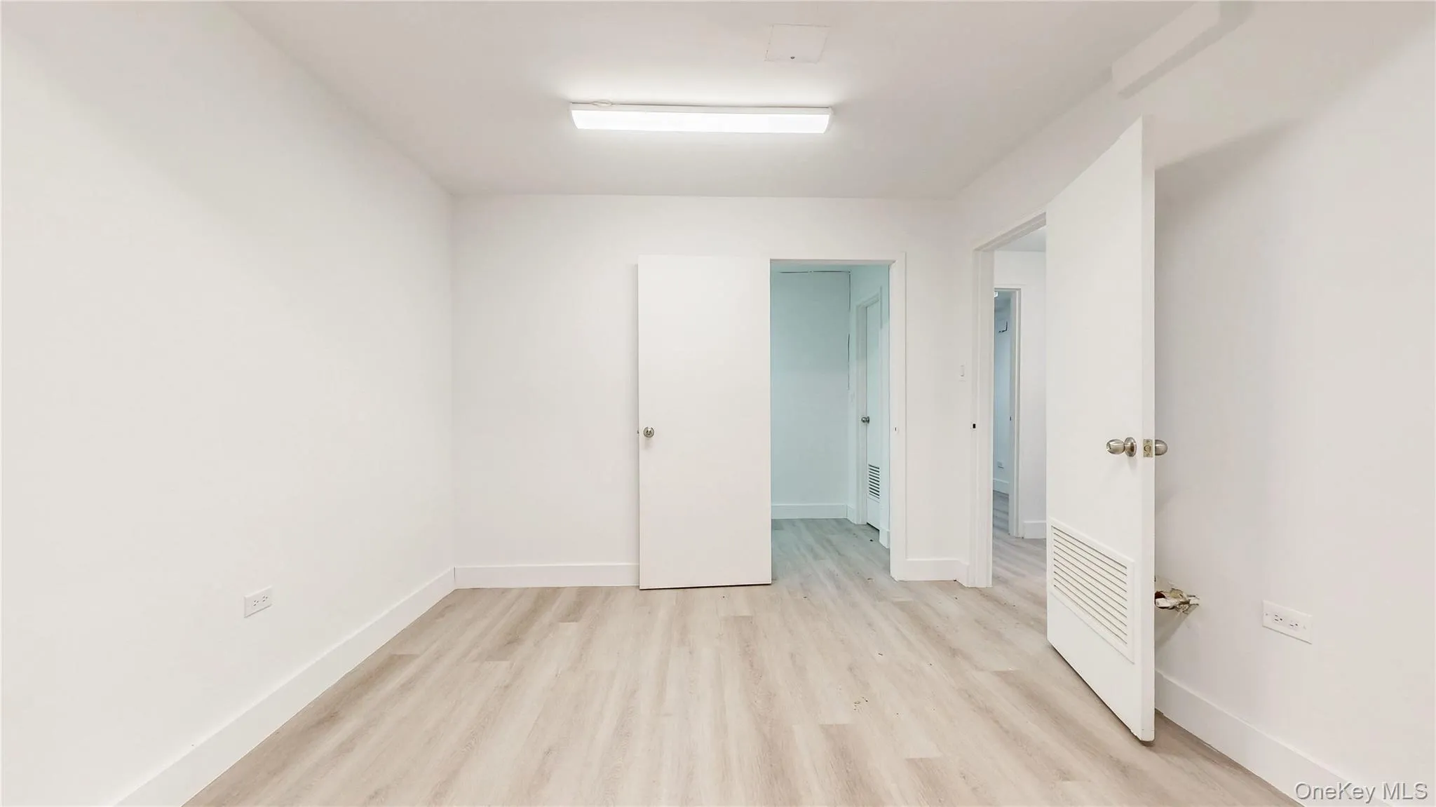 Unfurnished bedroom with light wood-style flooring and baseboards Unfurnished bedroom with light wood-style flooring and baseboards