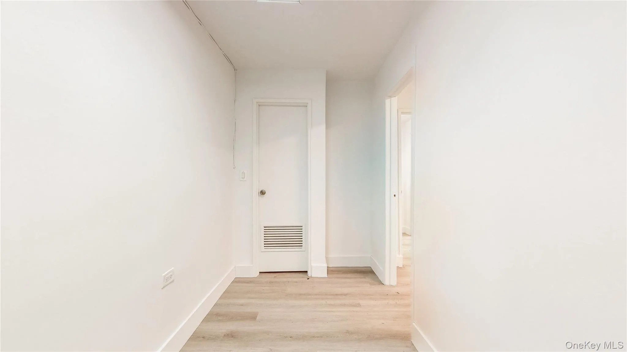Corridor with light wood-style flooring and baseboards Corridor with light wood-style flooring and baseboards
