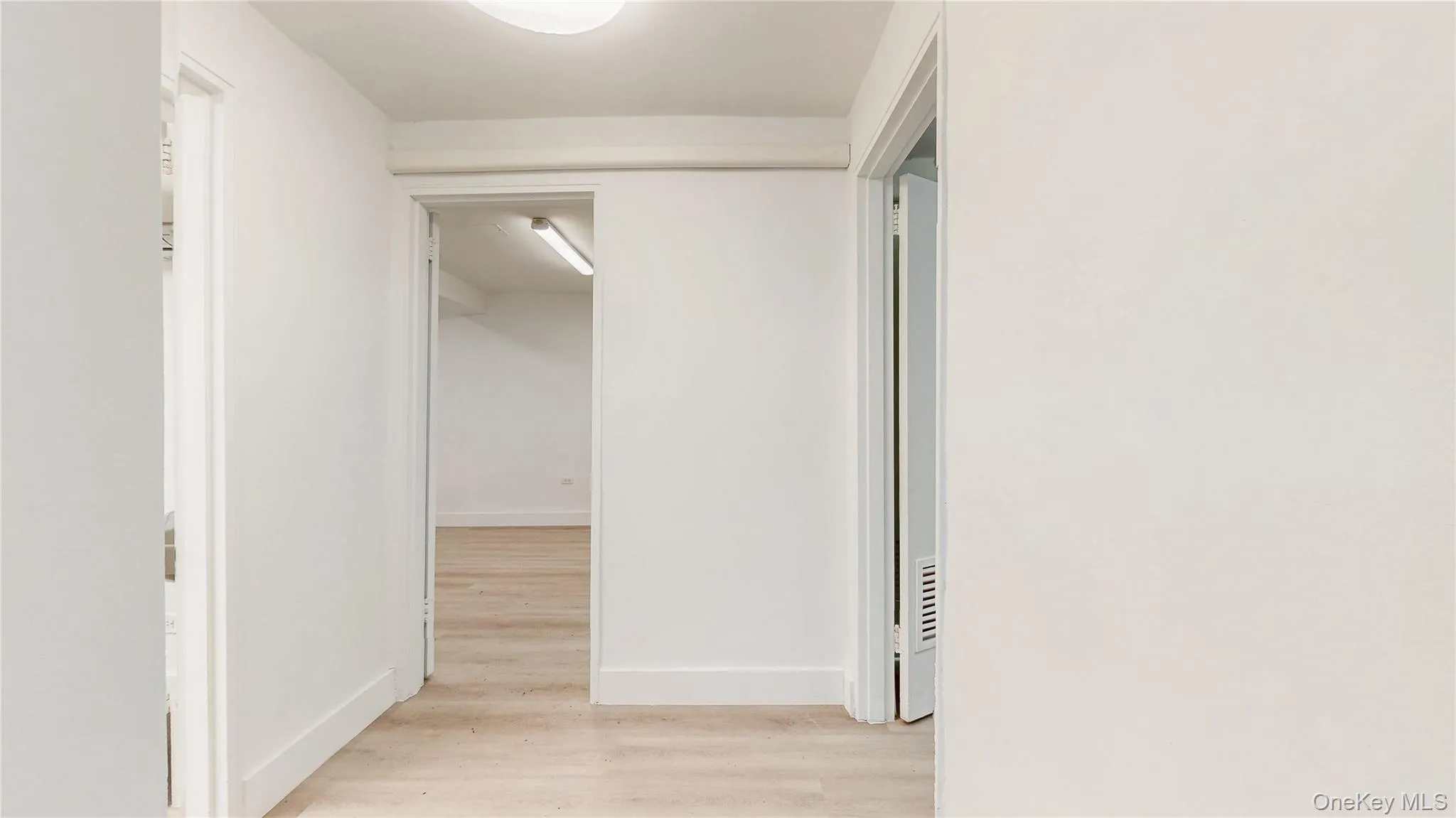 Hallway featuring light wood-style floors and baseboards Hallway featuring light wood-style floors and baseboards