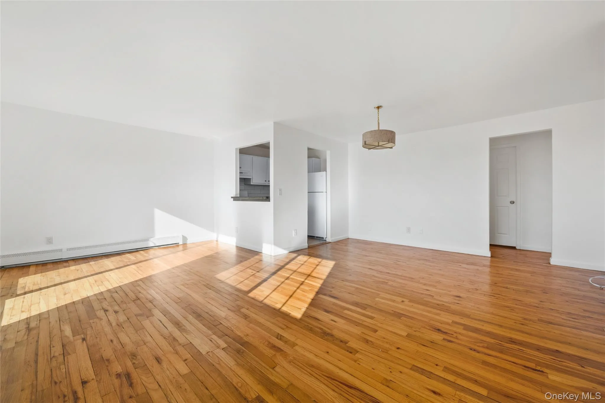 Spare room featuring light wood-type flooring and a baseboard radiator Spare room featuring light wood-type flooring and a baseboard radiator