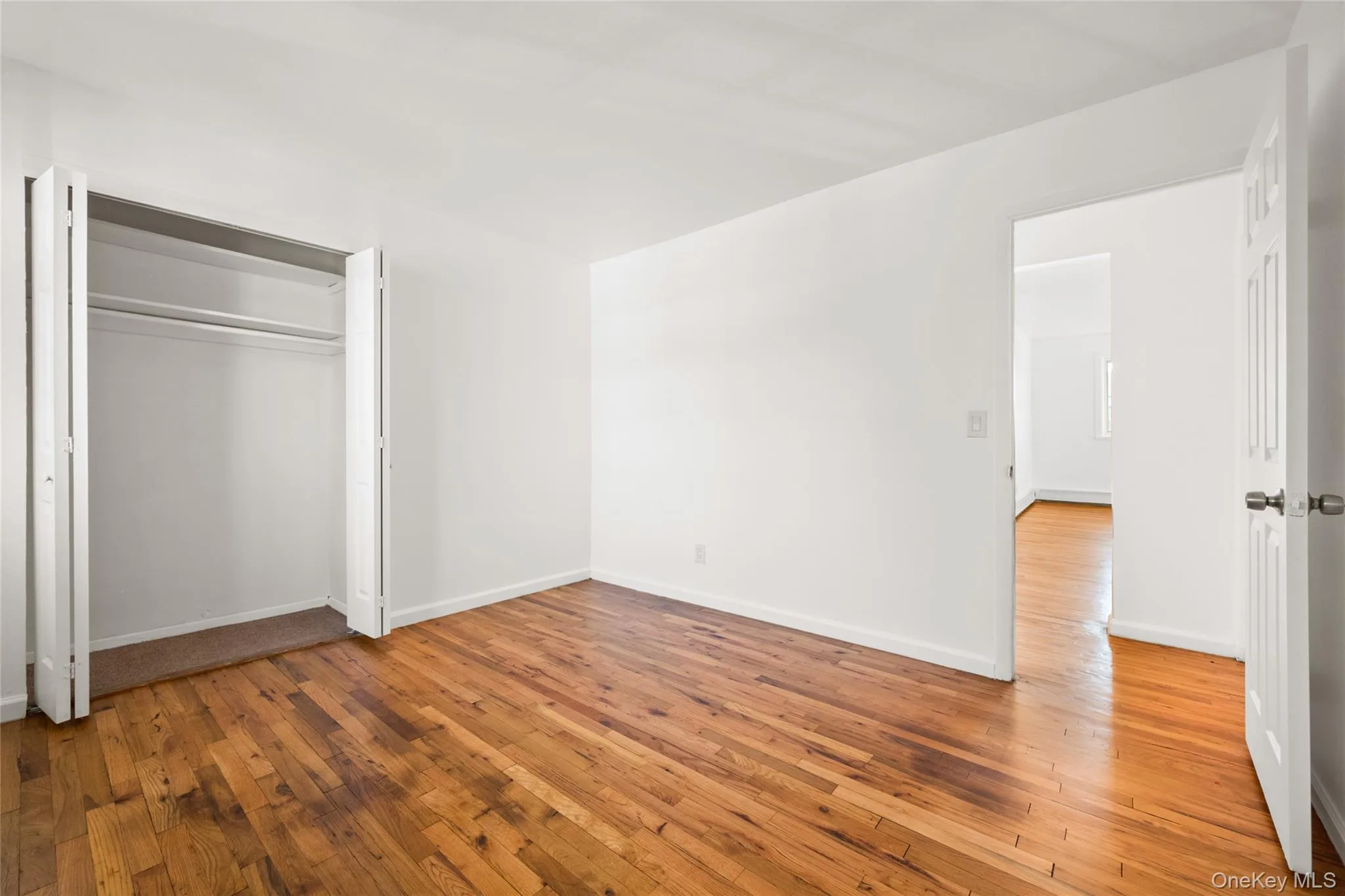 Unfurnished bedroom featuring light wood-style flooring and a closet Unfurnished bedroom featuring light wood-style flooring and a closet
