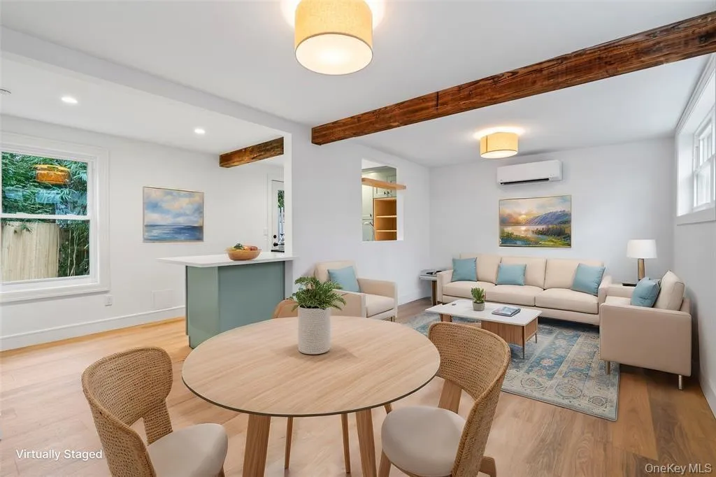 Dining space with plenty of natural light, beamed ceiling, a wall unit AC, light wood finished floors, and recessed lighting Dining space with plenty of natural light, beamed ceiling, a wall unit AC, light wood finished floors, and recessed lighting