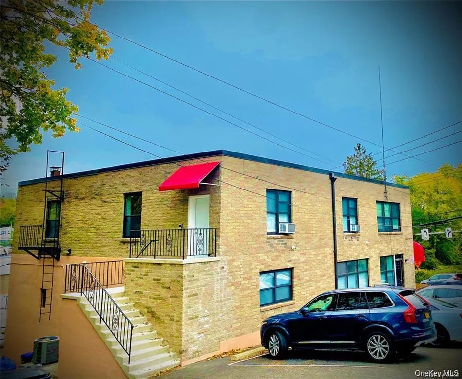 View of apartment building / complex featuring stairway and uncovered parking View of apartment building / complex featuring stairway and uncovered parking