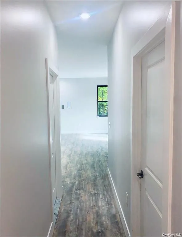 Corridor with baseboards and dark wood finished floors Corridor with baseboards and dark wood finished floors