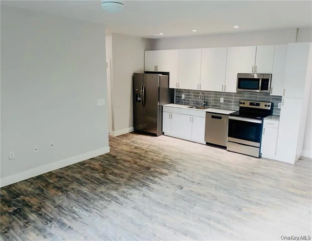 Kitchen featuring appliances with stainless steel finishes, white cabinetry, light countertops, and recessed lighting Kitchen featuring appliances with stainless steel finishes, white cabinetry, light countertops, and recessed lighting