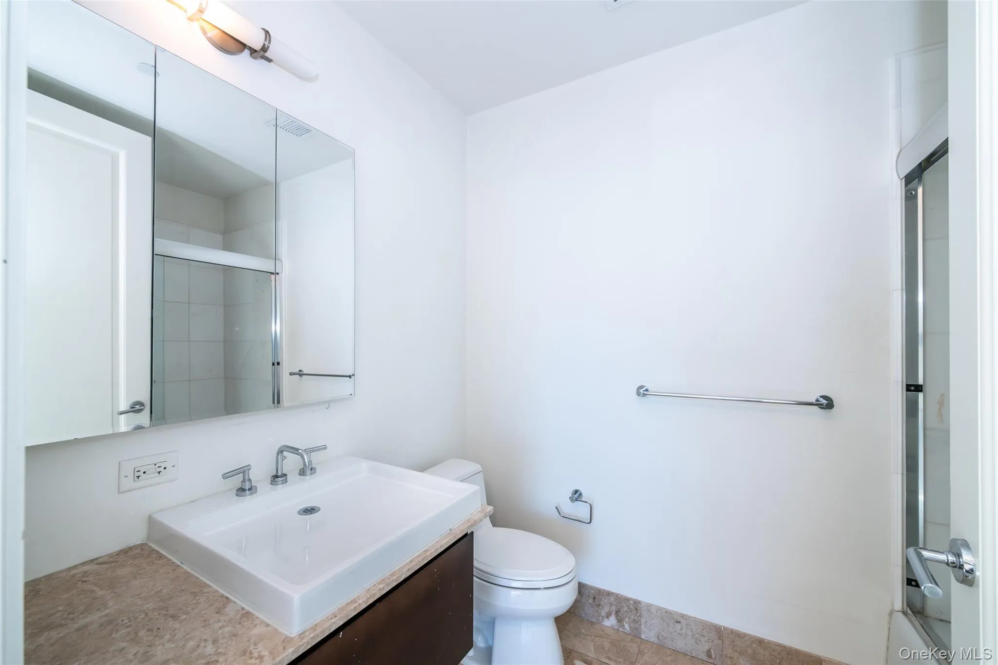 Second bedroom full bathroom featuring vanity and shower / bath combination with glass door Second bedroom full bathroom featuring vanity and shower / bath combination with glass door