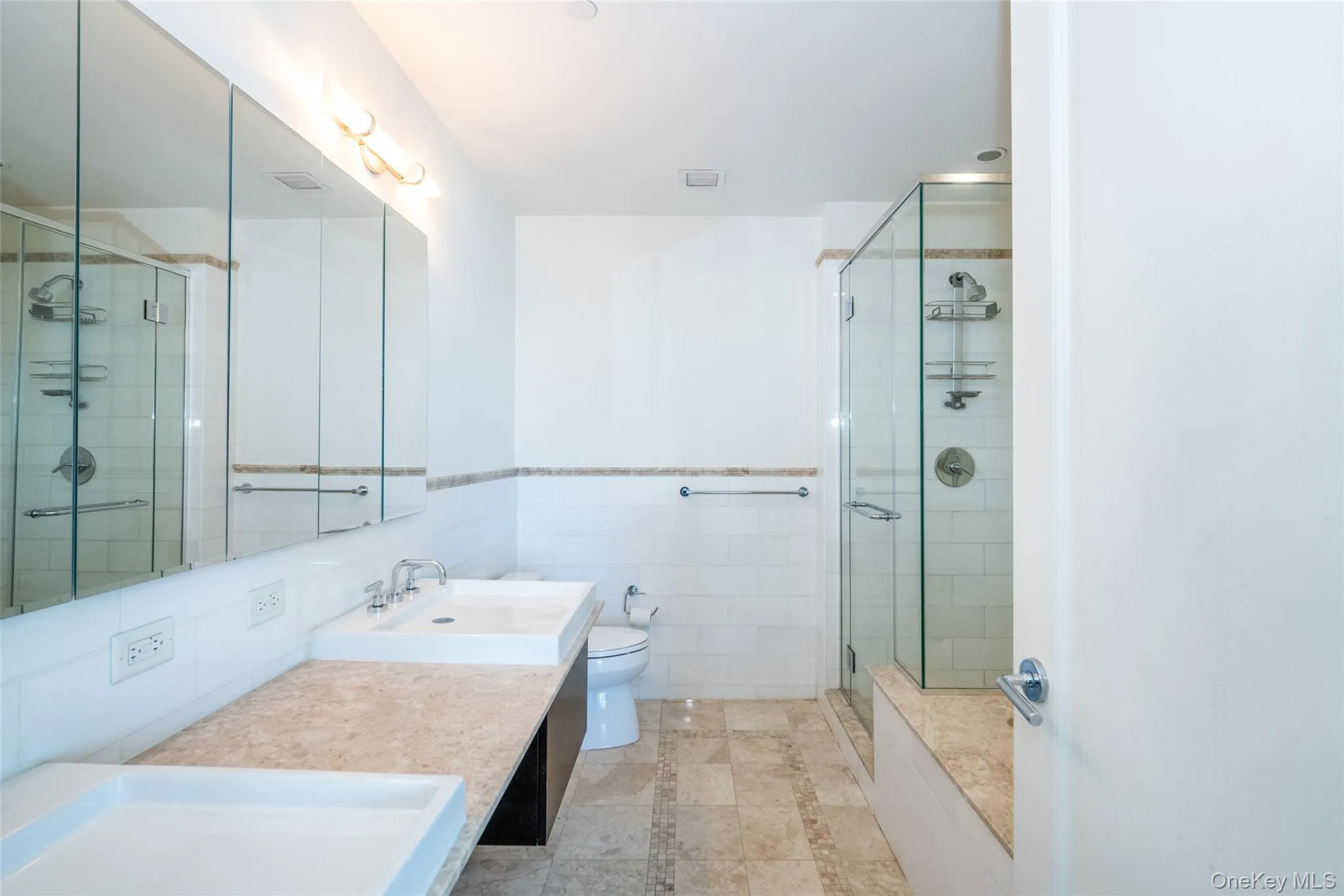 Full bathroom featuring double vanity, a shower stall, tile walls, Full bathroom featuring double vanity, a shower stall, tile walls,