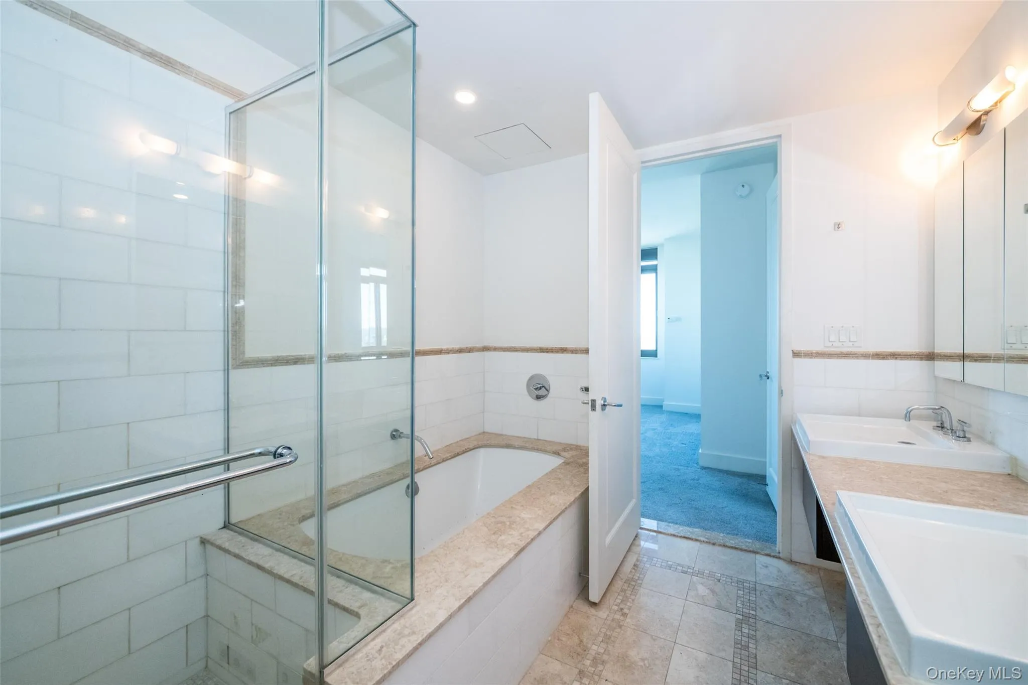 Bathroom featuring a garden tub, double vanity, a shower stall, inlaid floor details, and recessed lighting Bathroom featuring a garden tub, double vanity, a shower stall, inlaid floor details, and recessed lighting