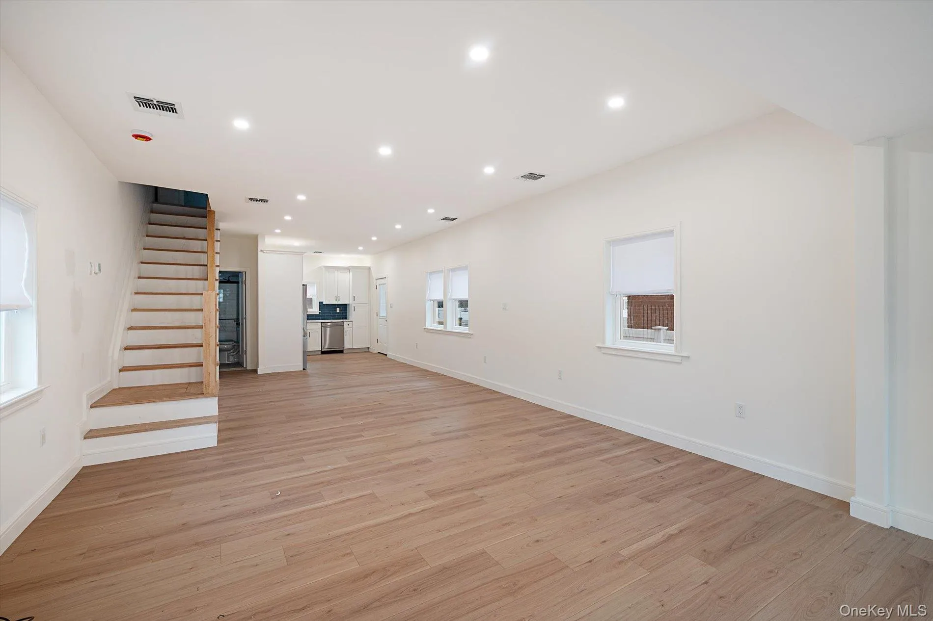 Unfurnished living room with stairway, recessed lighting, and light wood-style floors Unfurnished living room with stairway, recessed lighting, and light wood-style floors