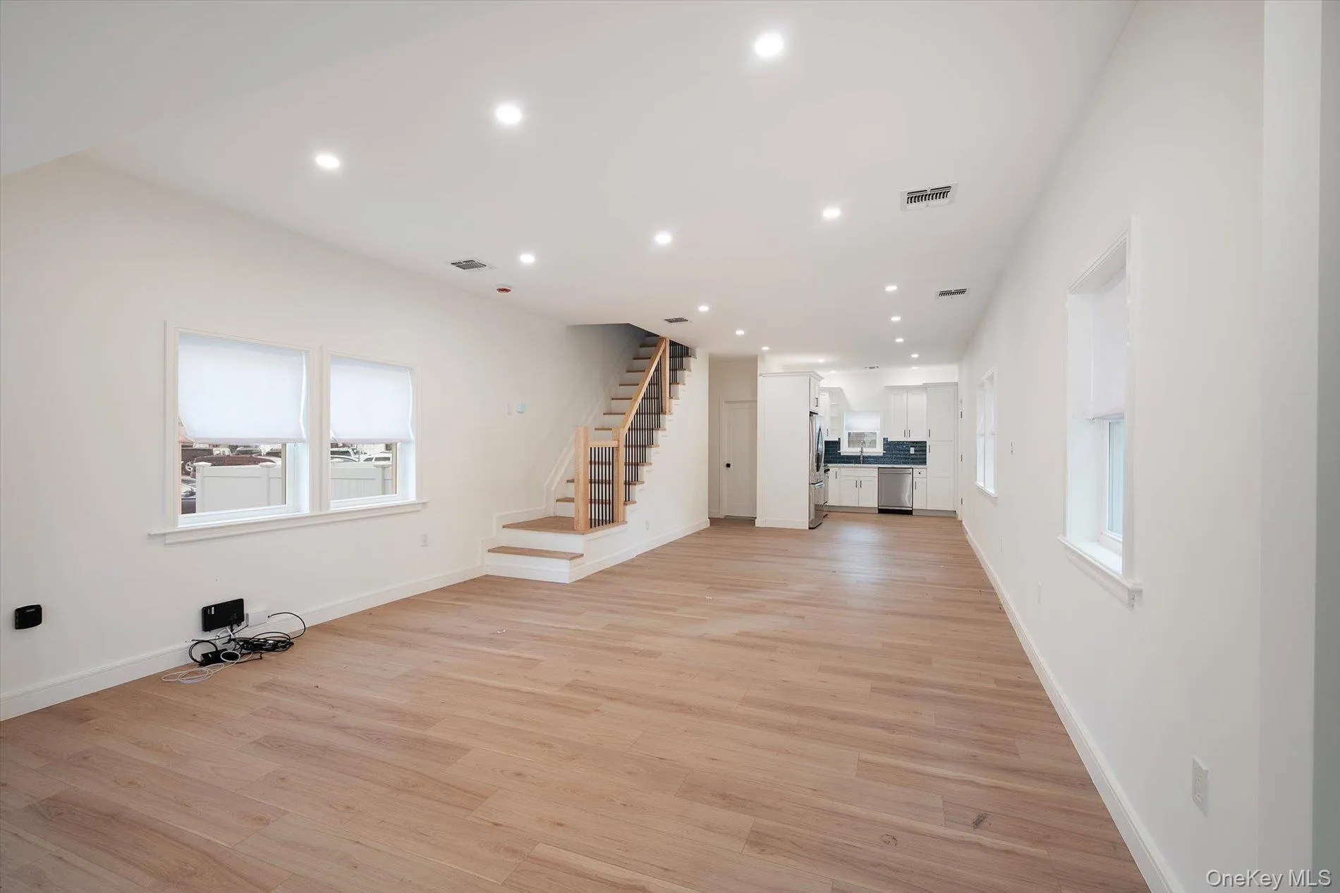 Unfurnished living room featuring recessed lighting, stairs, and light wood-type flooring Unfurnished living room featuring recessed lighting, stairs, and light wood-type flooring