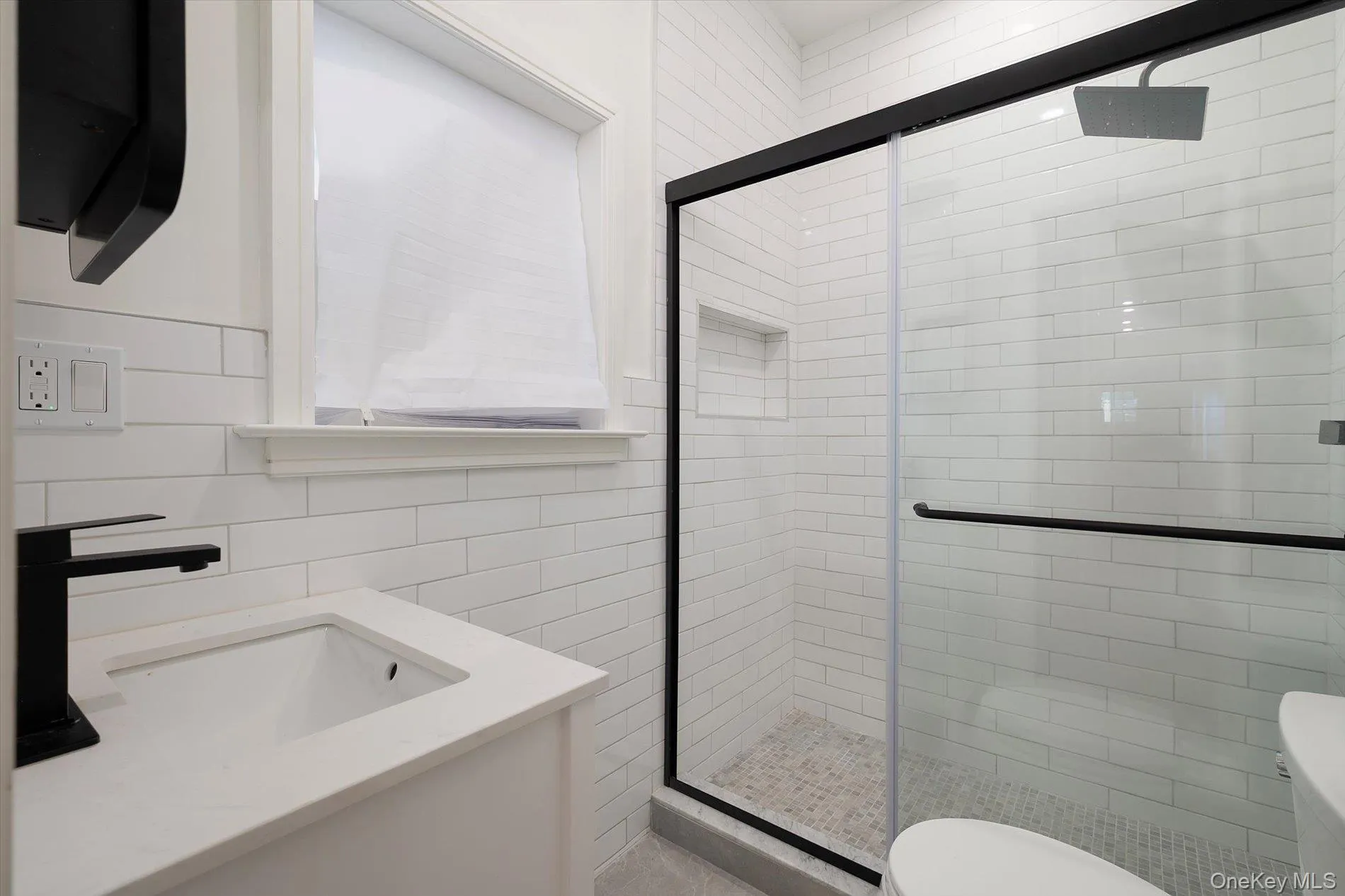 Full bath featuring vanity, a shower stall, and tile walls Full bath featuring vanity, a shower stall, and tile walls