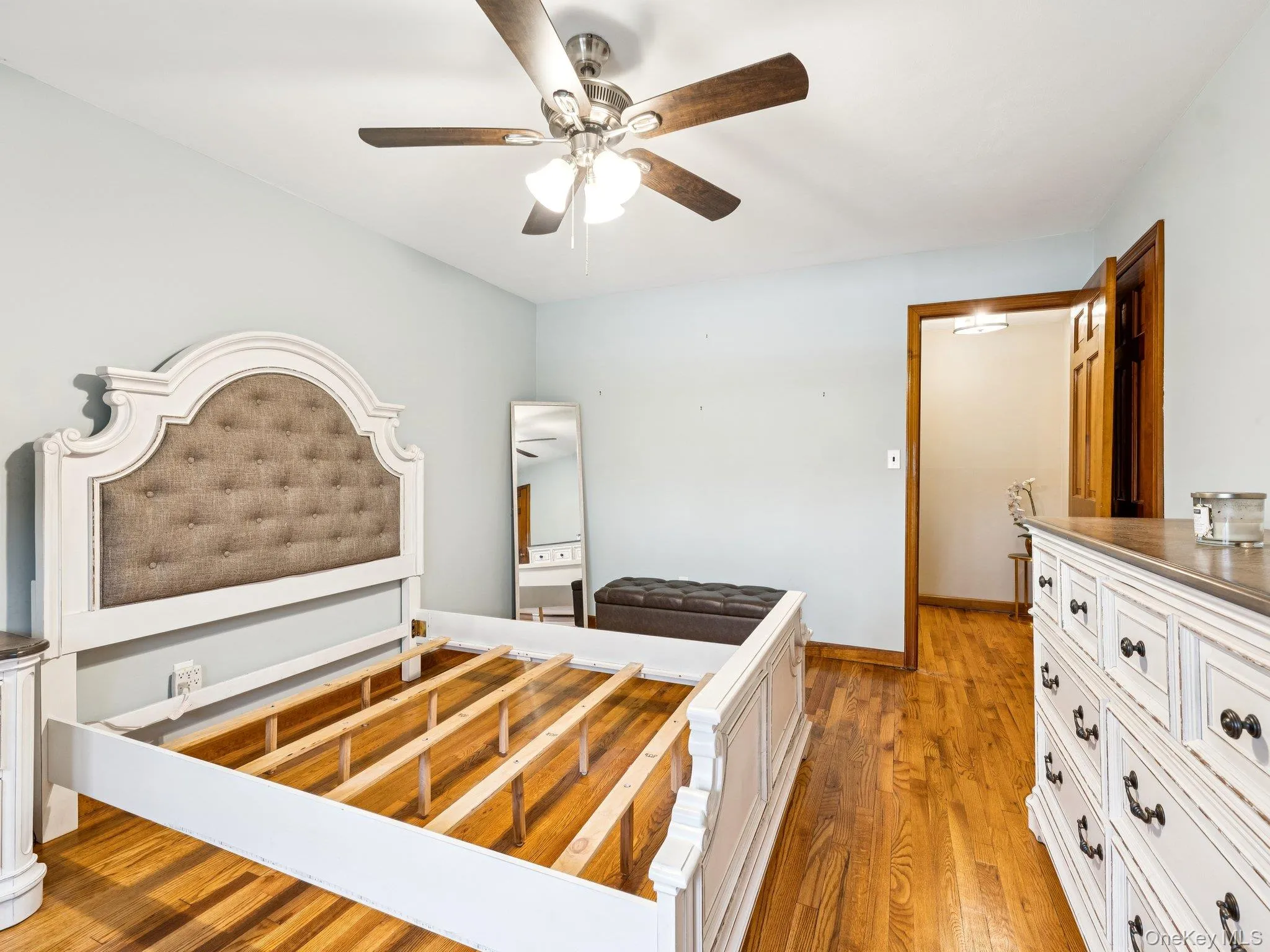 Bedroom featuring light wood finished floors and a ceiling fan Bedroom featuring light wood finished floors and a ceiling fan