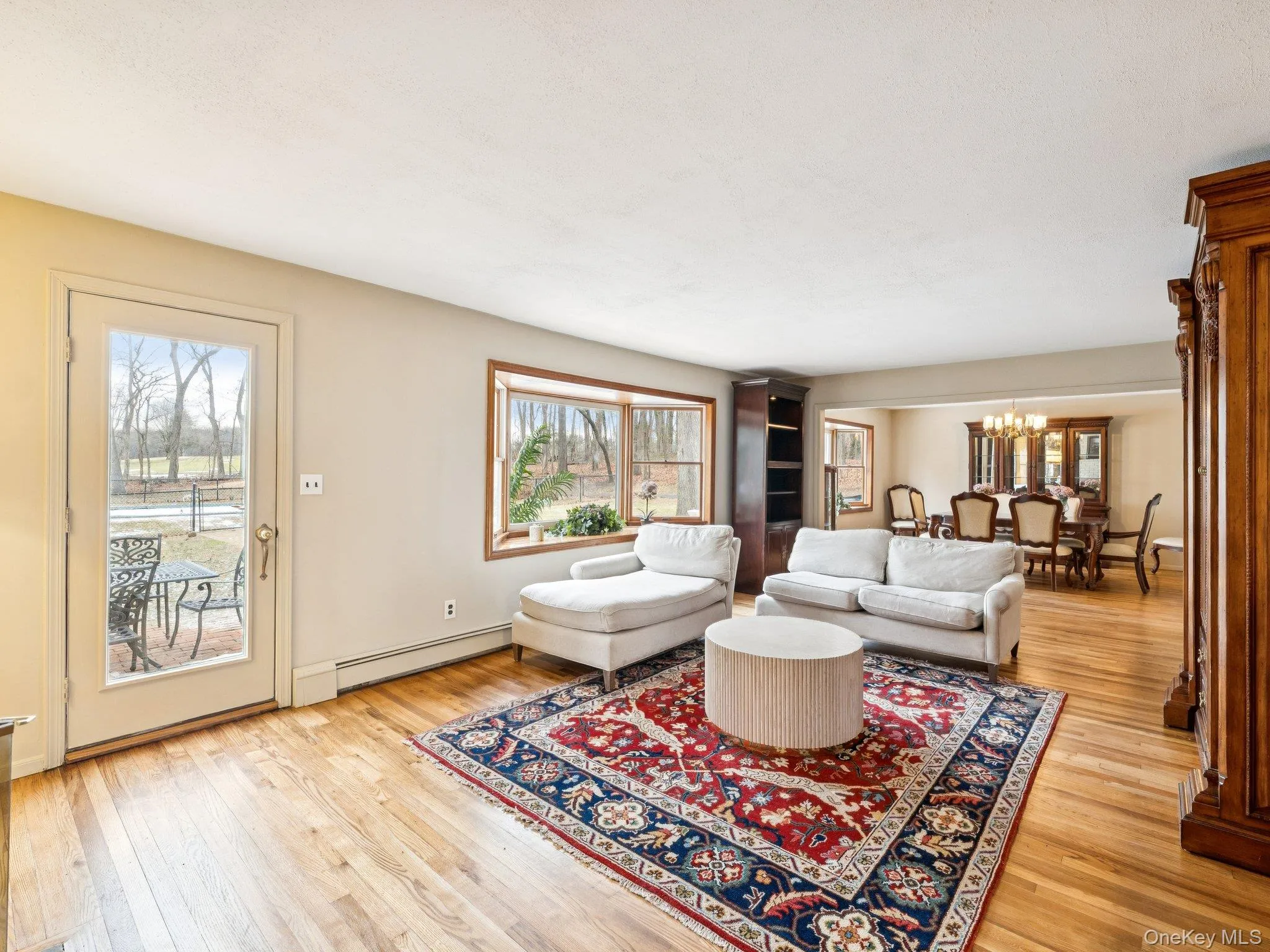 Living area with a chandelier, a baseboard heating unit, healthy amount of natural light, and light wood finished floors Living area with a chandelier, a baseboard heating unit, healthy amount of natural light, and light wood finished floors