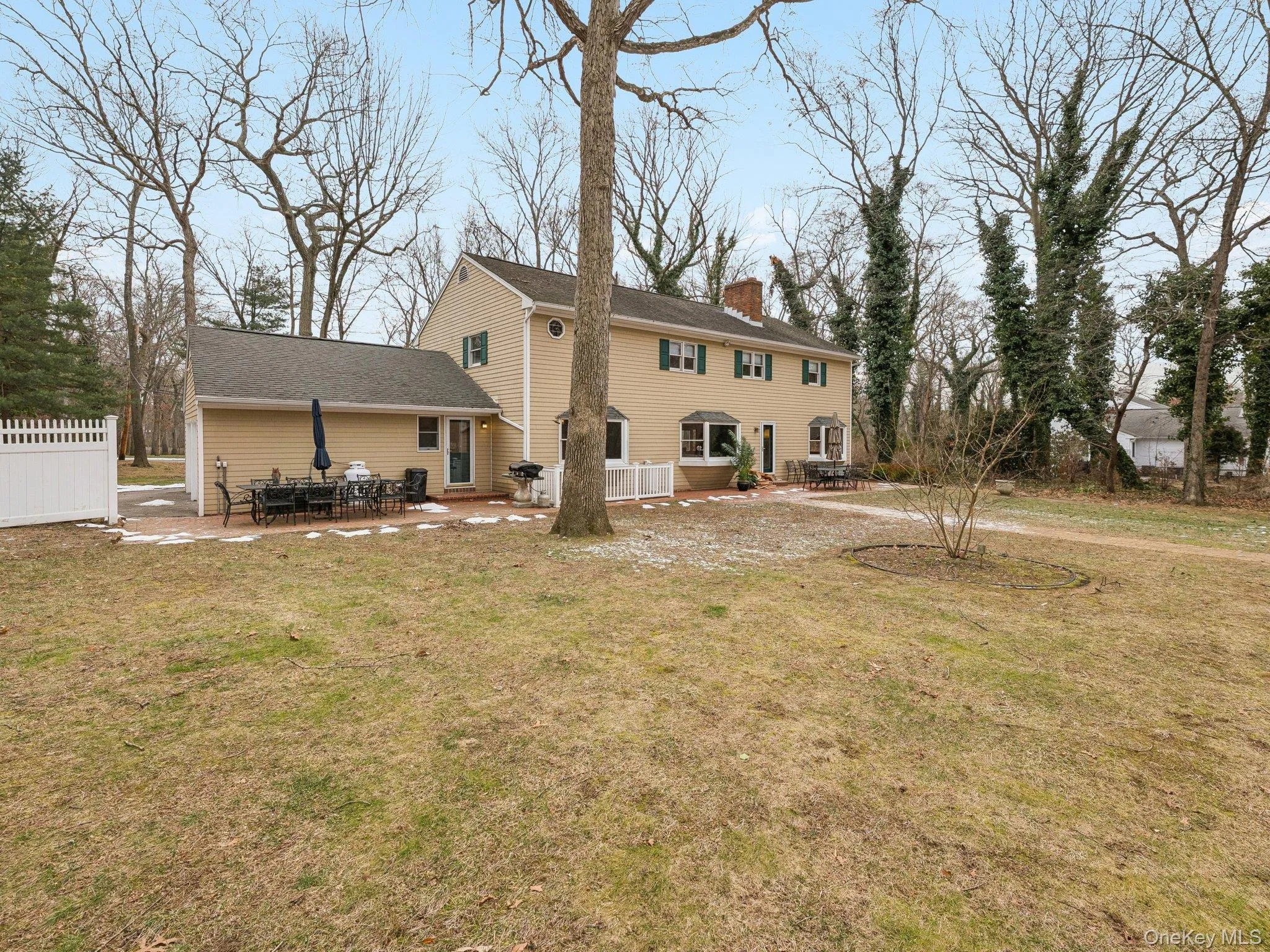Rear view of property with a patio area, a lawn, and a chimney Rear view of property with a patio area, a lawn, and a chimney