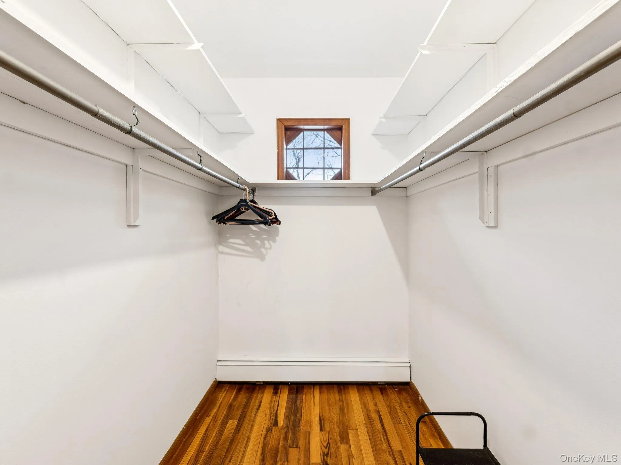 Spacious closet with wood finished floors and a baseboard radiator Spacious closet with wood finished floors and a baseboard radiator