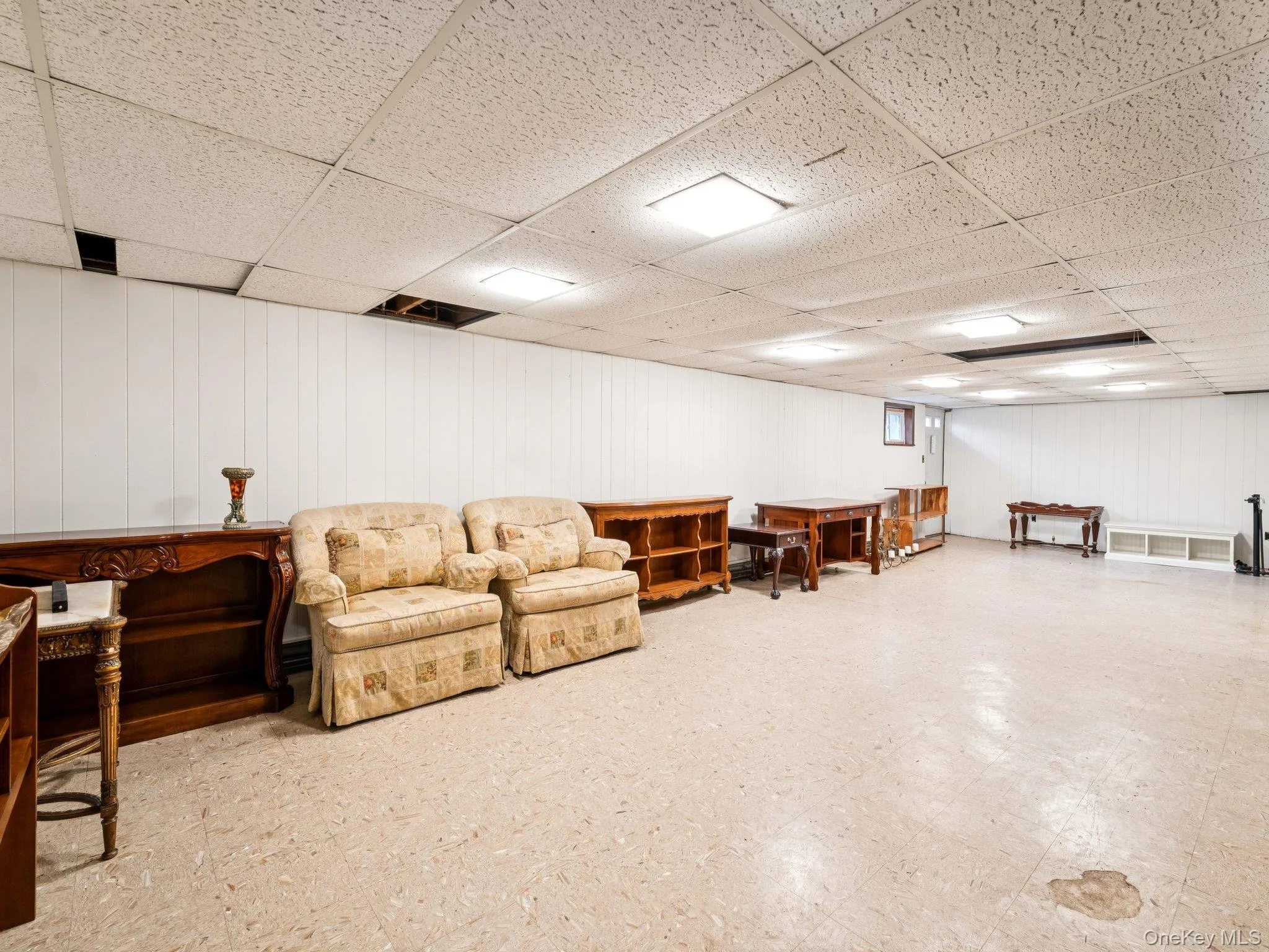 Living area with tile patterned floors and a drop ceiling Living area with tile patterned floors and a drop ceiling