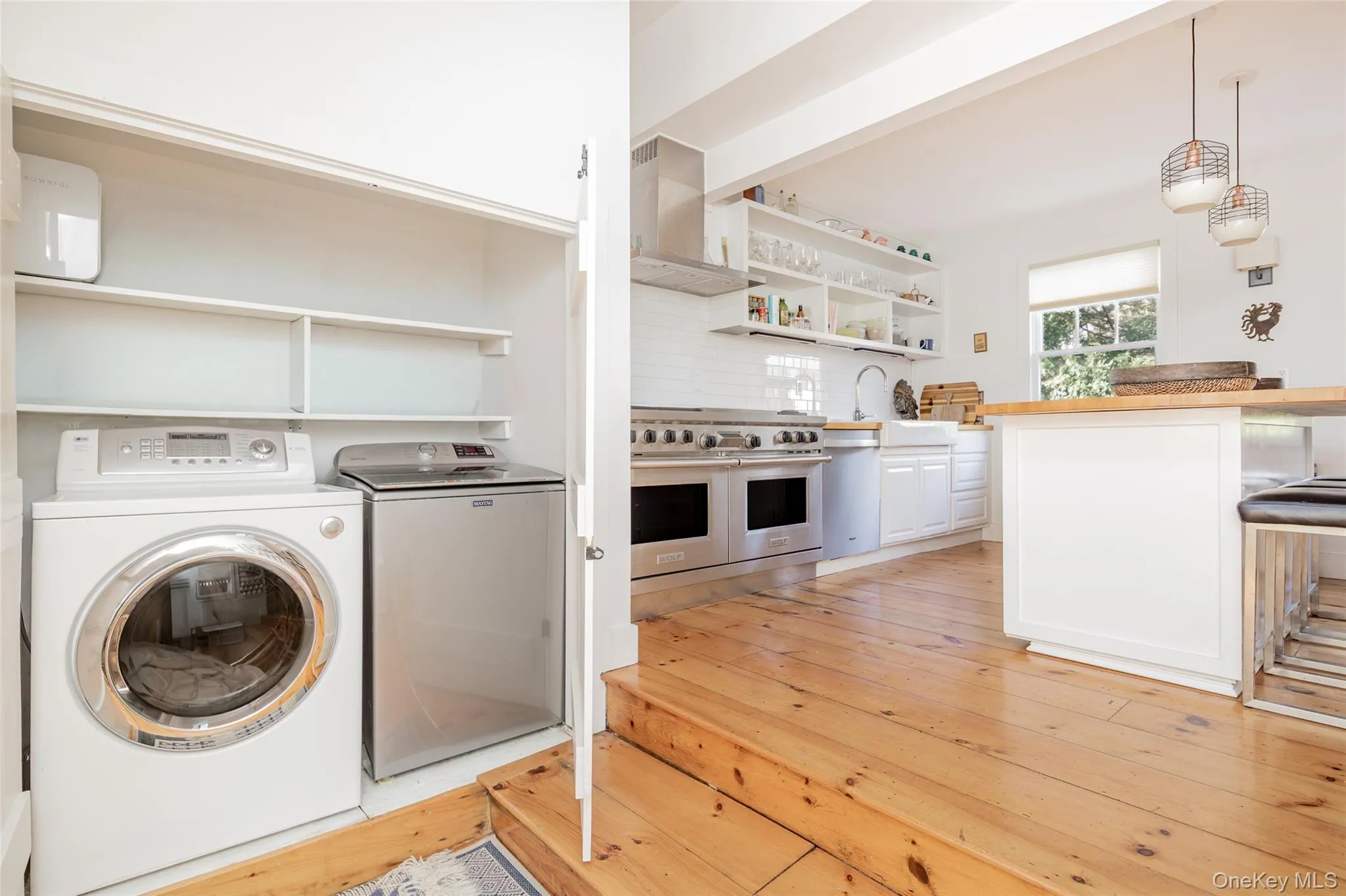 Laundry area with washer and dryer and light wood-style flooring Laundry area with washer and dryer and light wood-style flooring