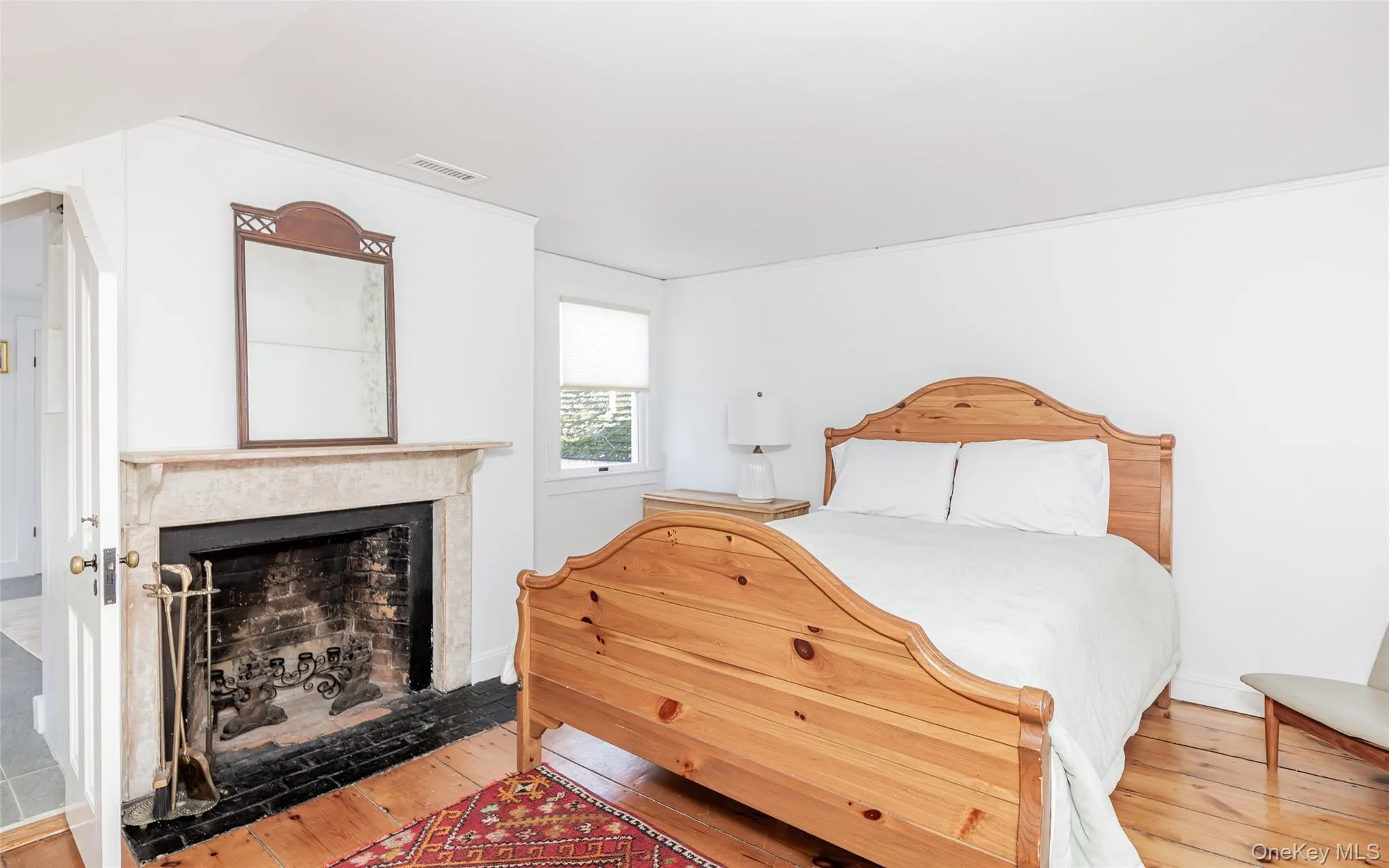 Bedroom featuring wood-type flooring and a fireplace with flush hearth Bedroom featuring wood-type flooring and a fireplace with flush hearth