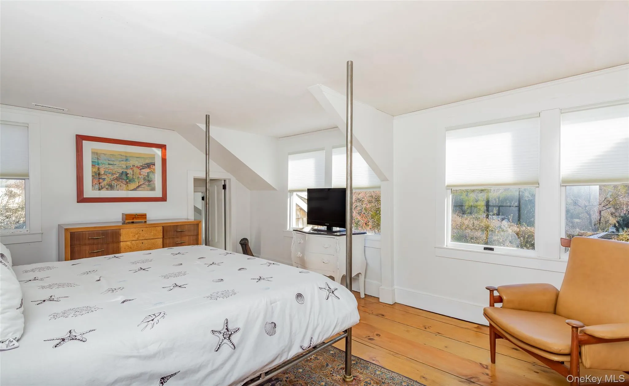 Bedroom with multiple windows and hardwood / wood-style floors Bedroom with multiple windows and hardwood / wood-style floors
