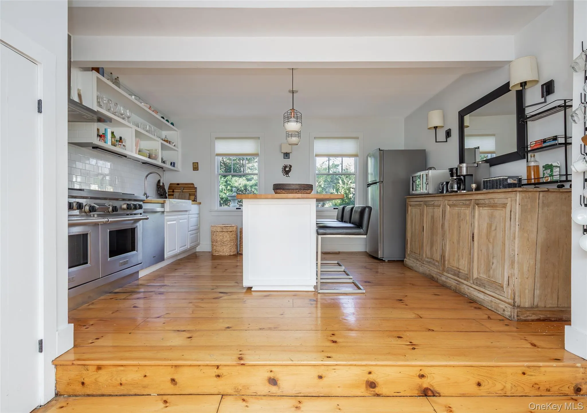 Kitchen with a kitchen breakfast bar, pendant lighting, stainless steel appliances, backsplash, and a center island Kitchen with a kitchen breakfast bar, pendant lighting, stainless steel appliances, backsplash, and a center island