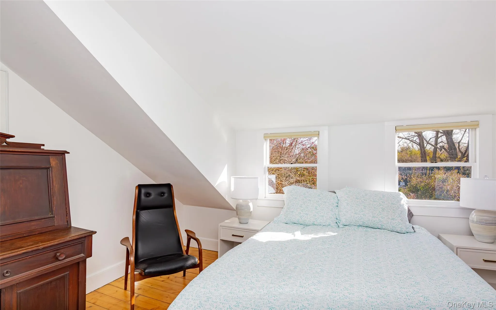 Bedroom with light wood-style flooring and multiple windows Bedroom with light wood-style flooring and multiple windows