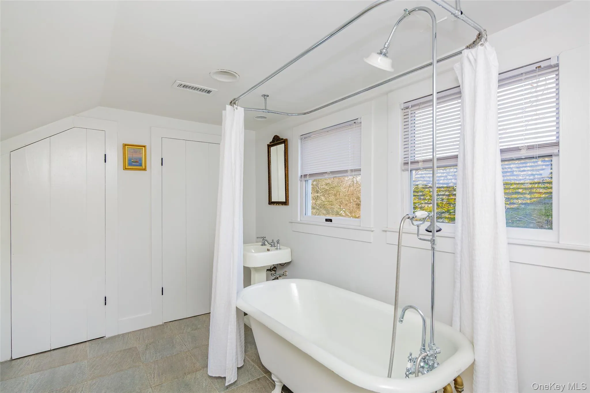 Bathroom with a freestanding tub and vaulted ceiling Bathroom with a freestanding tub and vaulted ceiling