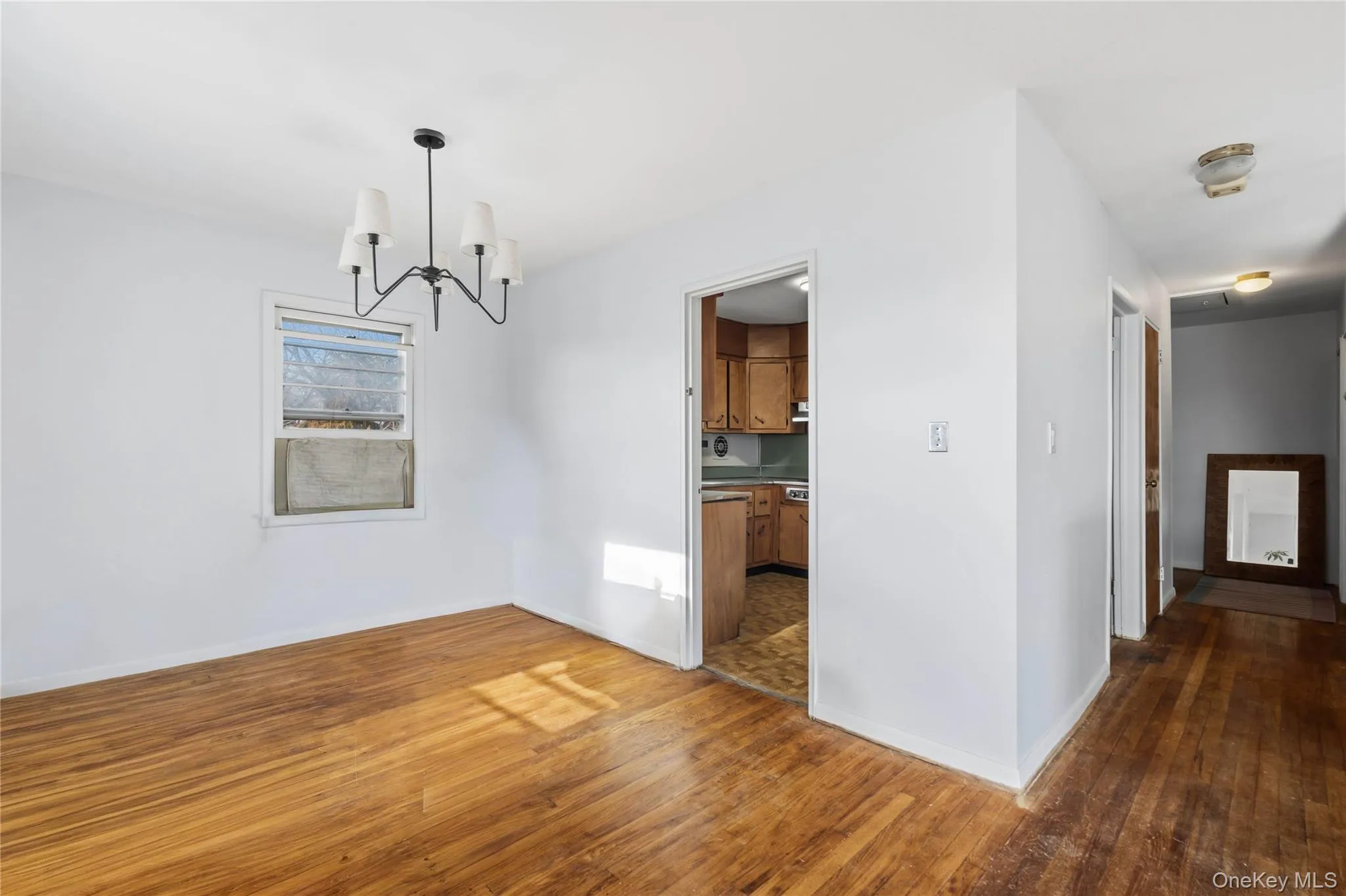 Unfurnished dining area featuring a chandelier and hardwood / wood-style flooring Unfurnished dining area featuring a chandelier and hardwood / wood-style flooring